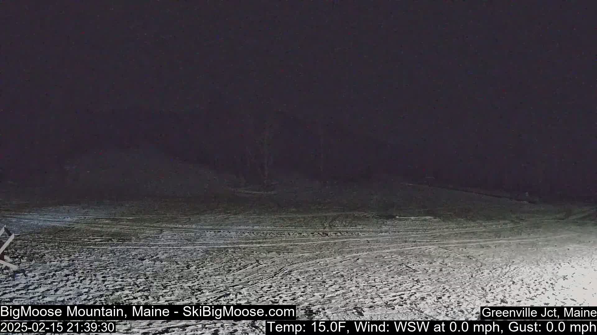 A snow-covered landscape is visible at night under a dark sky.