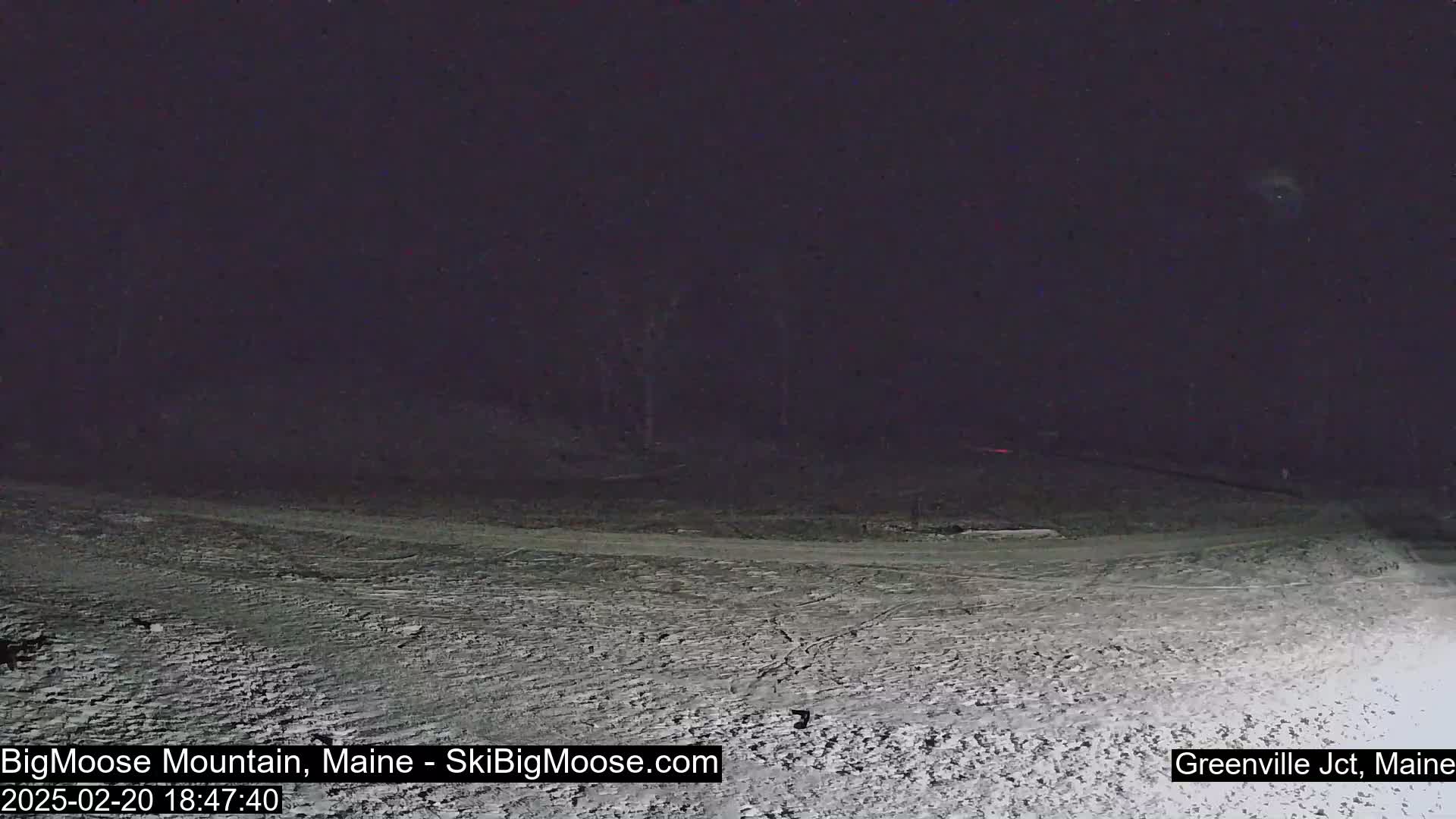 A snow-covered landscape is visible at night under a dark sky.