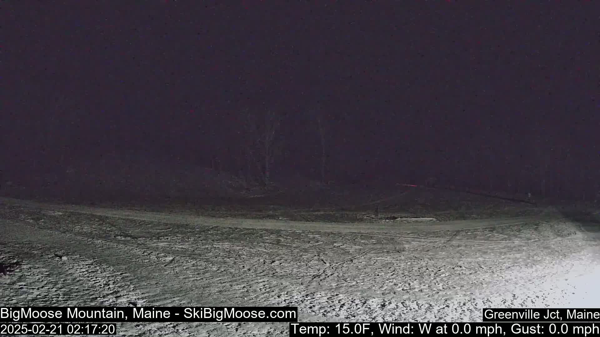 A snow-covered landscape is visible at night under a dark sky.