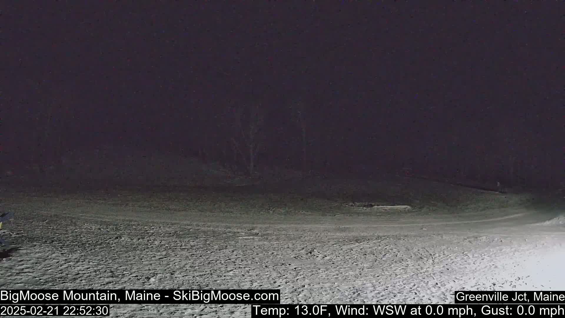 A snow-covered, dark landscape is visible at night under a clear sky, with a calm wind and a temperature of 13 degrees Fahrenheit.