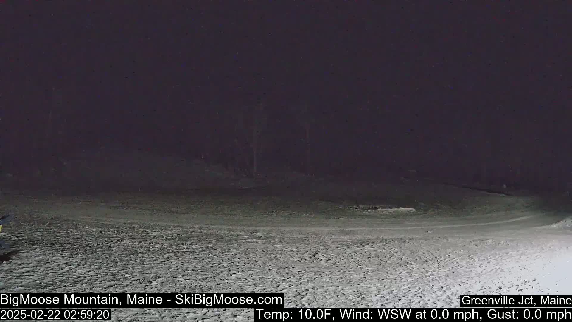 A snow-covered area is visible at night under a dark sky, with calm weather conditions.