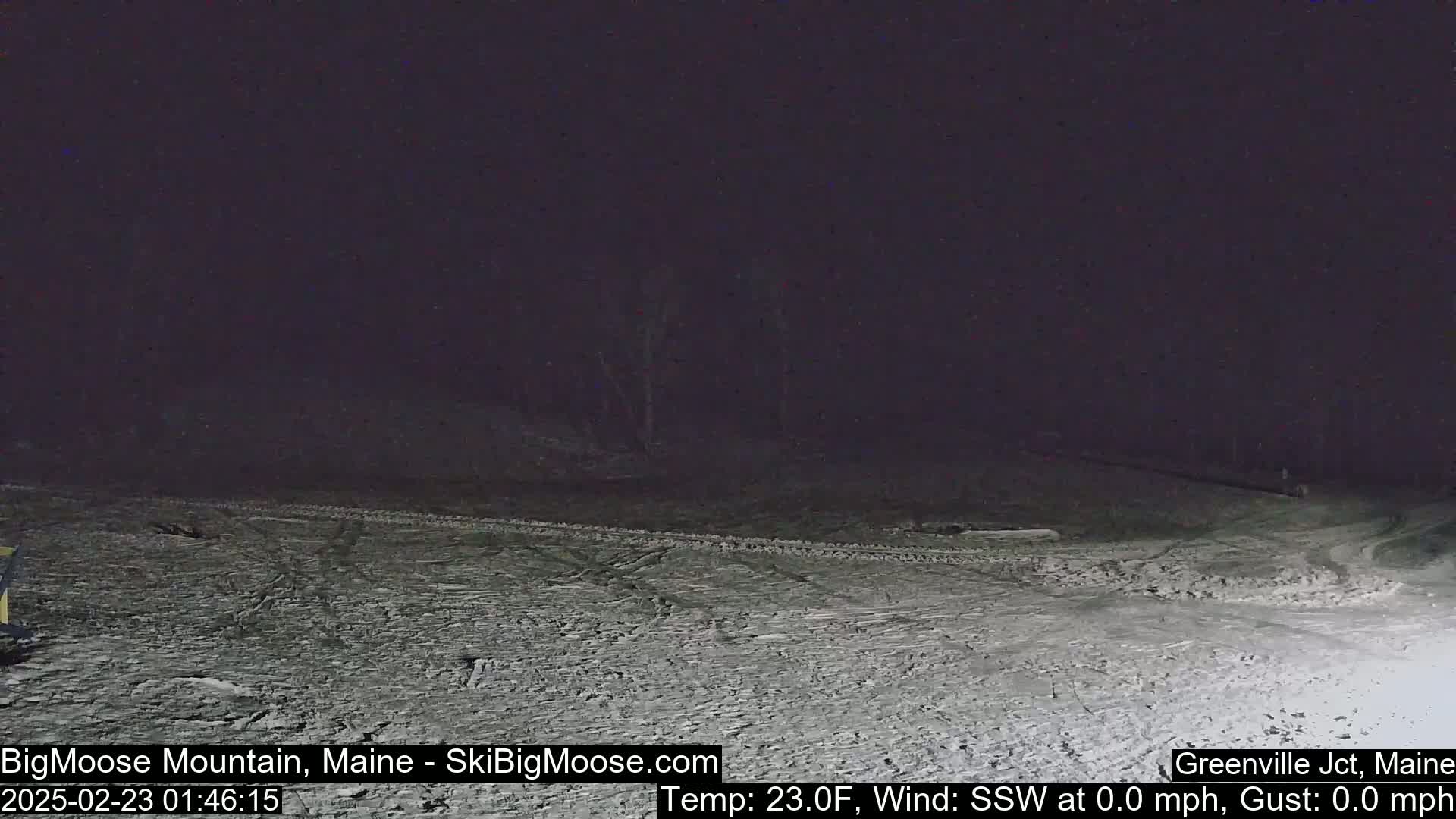 A snow-covered, dark landscape is visible at night under a clear sky.