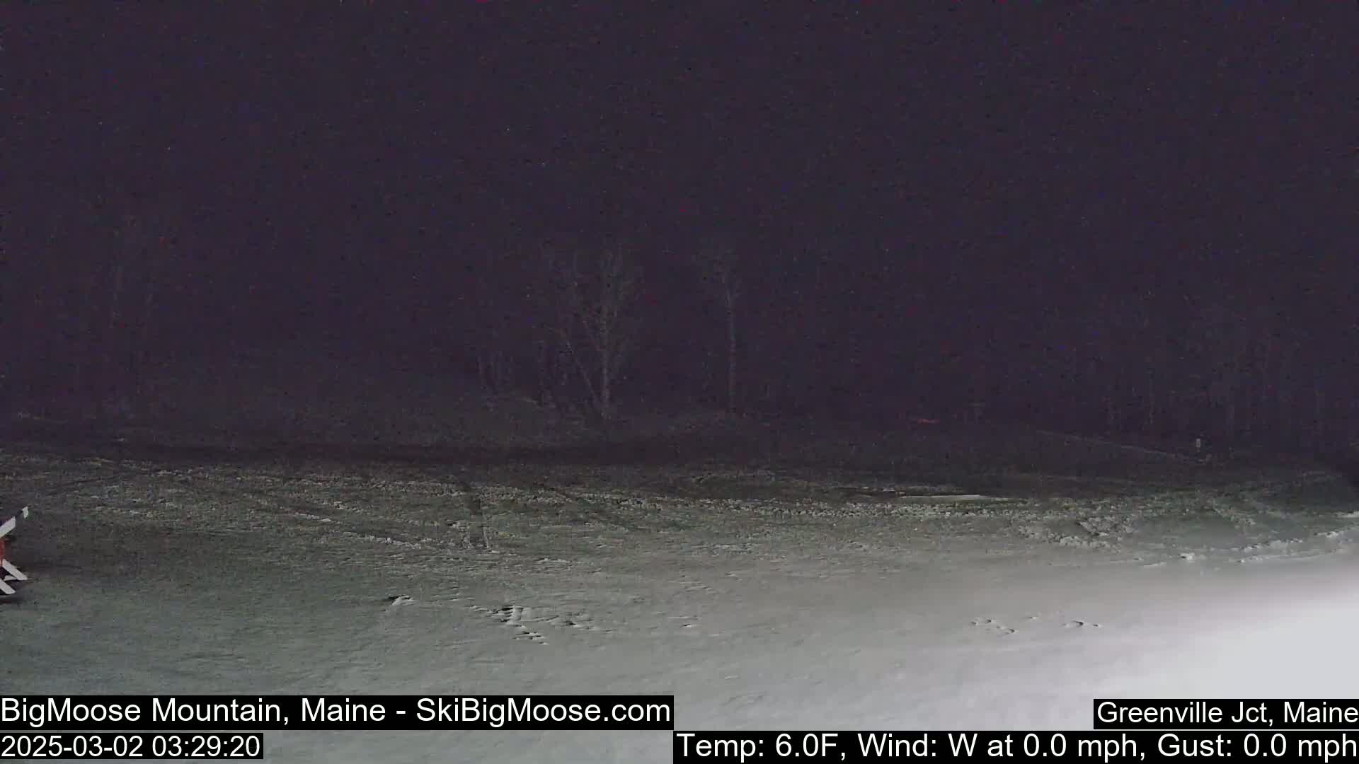 A snow-covered landscape is visible at night under a dark sky.