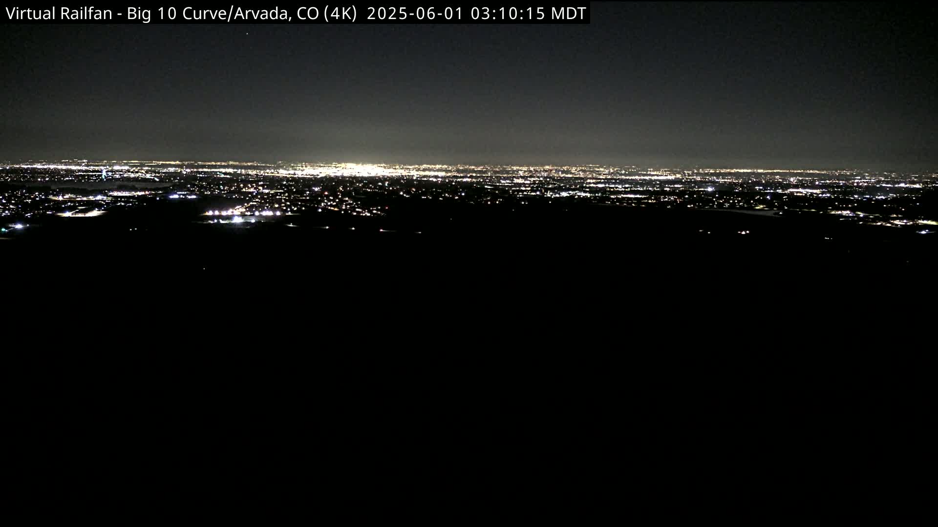 A nighttime long shot shows a sprawling city's lights on the horizon.
