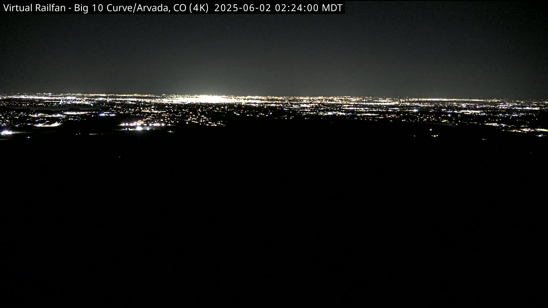 A nighttime, long-distance view of a city skyline illuminated by many small lights.