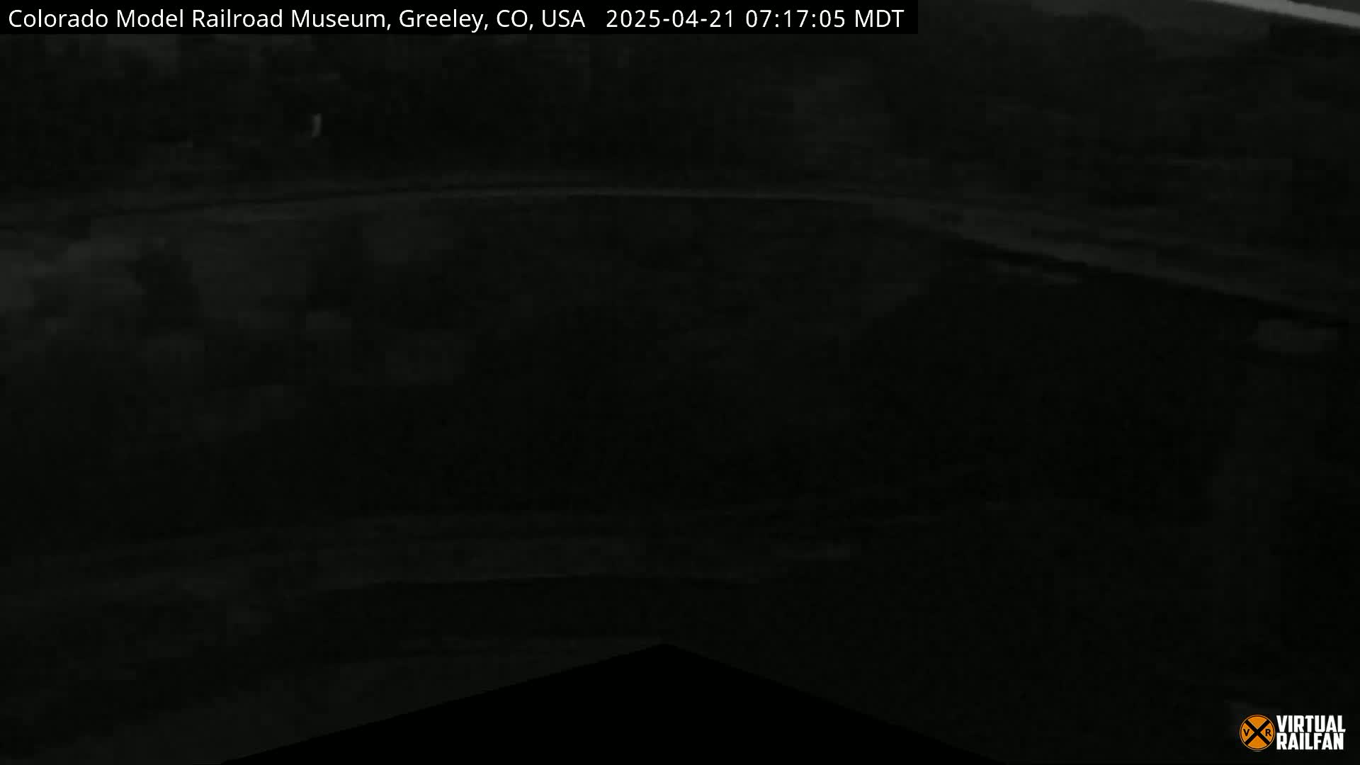 A dark, nighttime image shows an indistinct, mostly black area, possibly a roadway or parking lot.