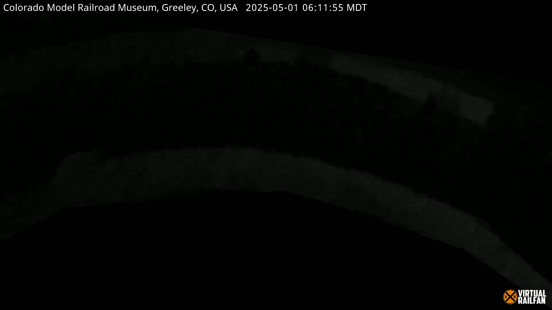 A dark, blurry image shows a dimly lit, curved structure at night.