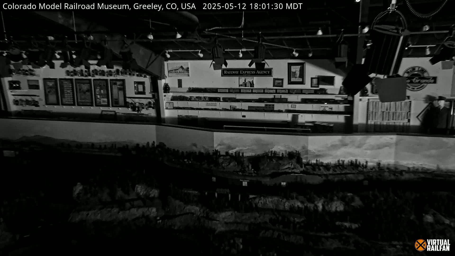 An extensive model railroad layout is displayed indoors, under artificial lighting, within a museum setting.