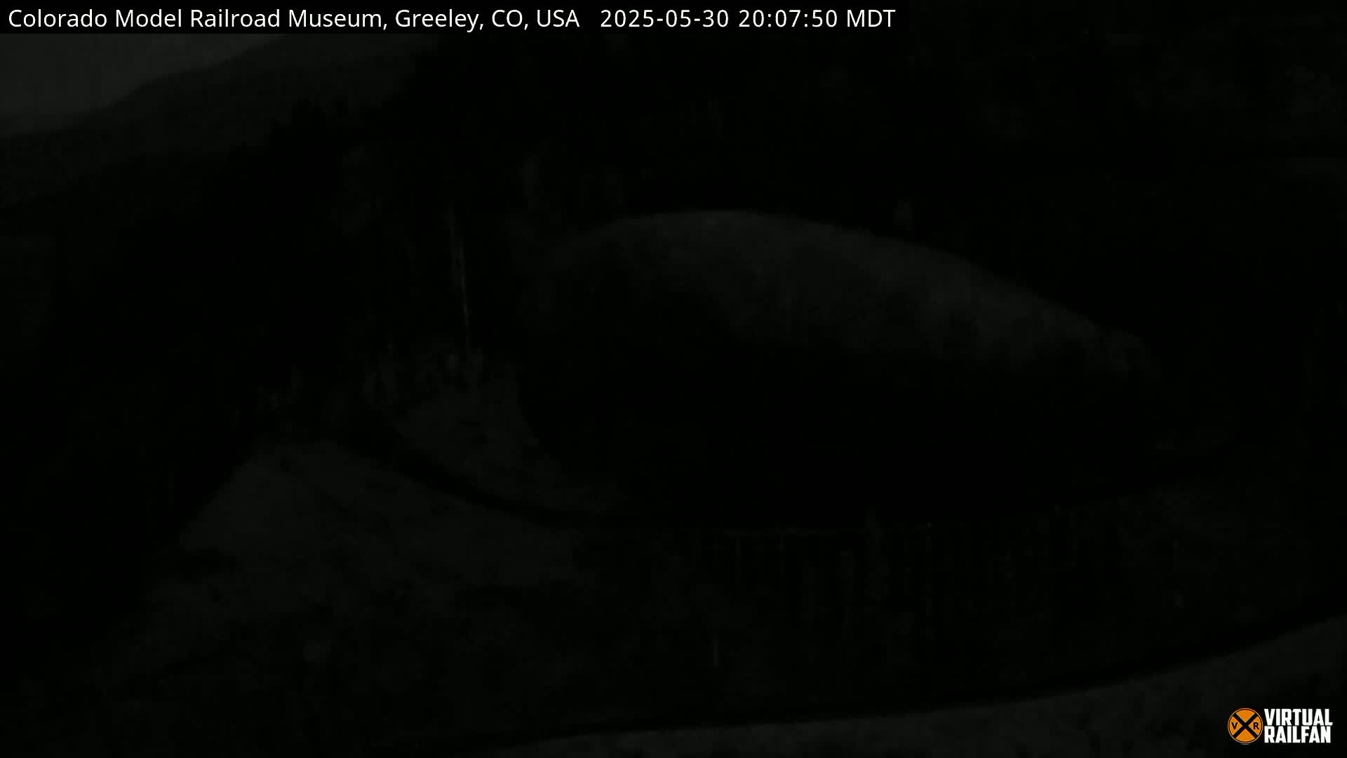 A very dark, nighttime image shows an indistinct, dark landscape.