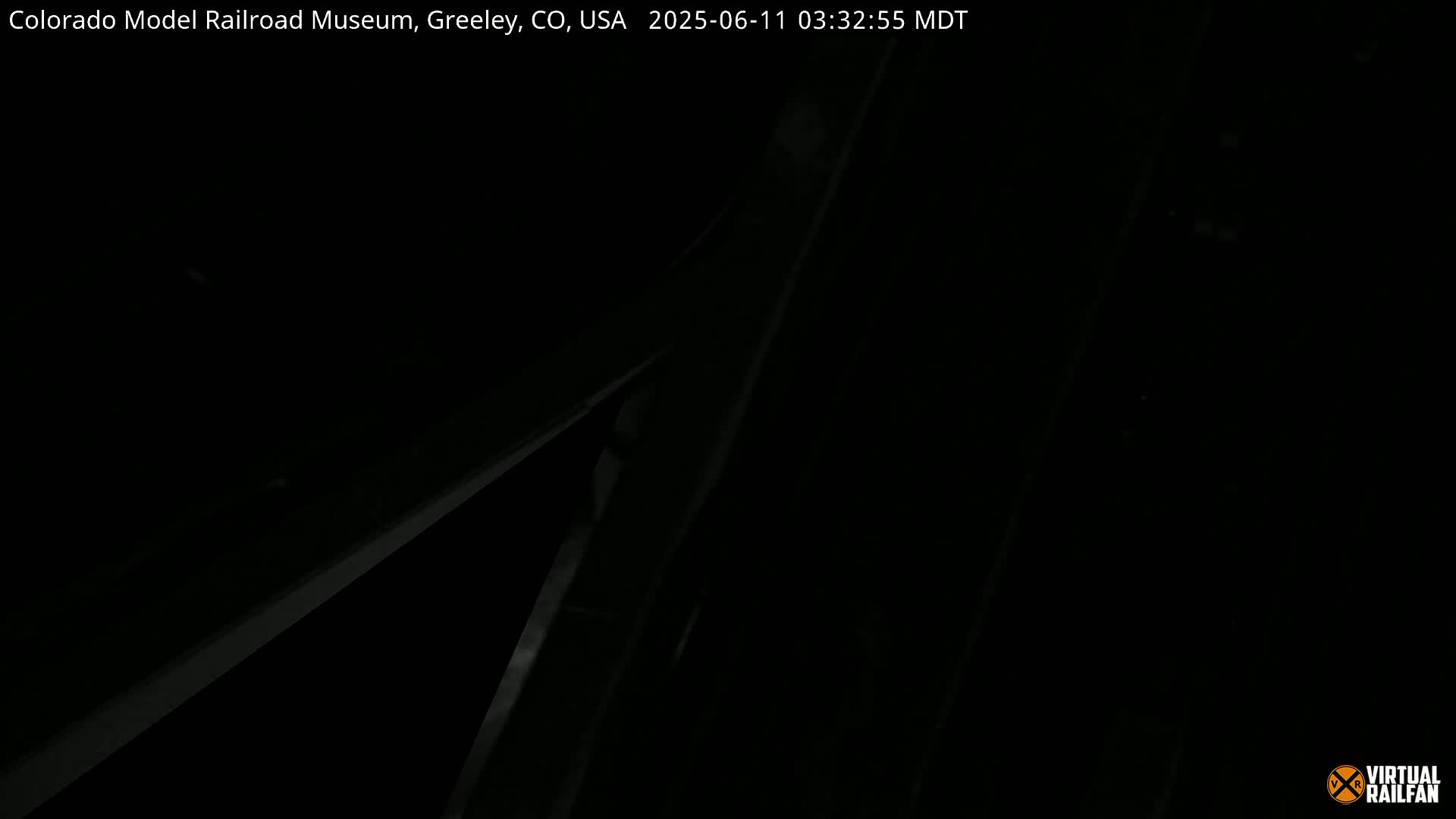 A dark, nighttime image shows what appears to be the corner of a building or structure with some indistinct details visible.