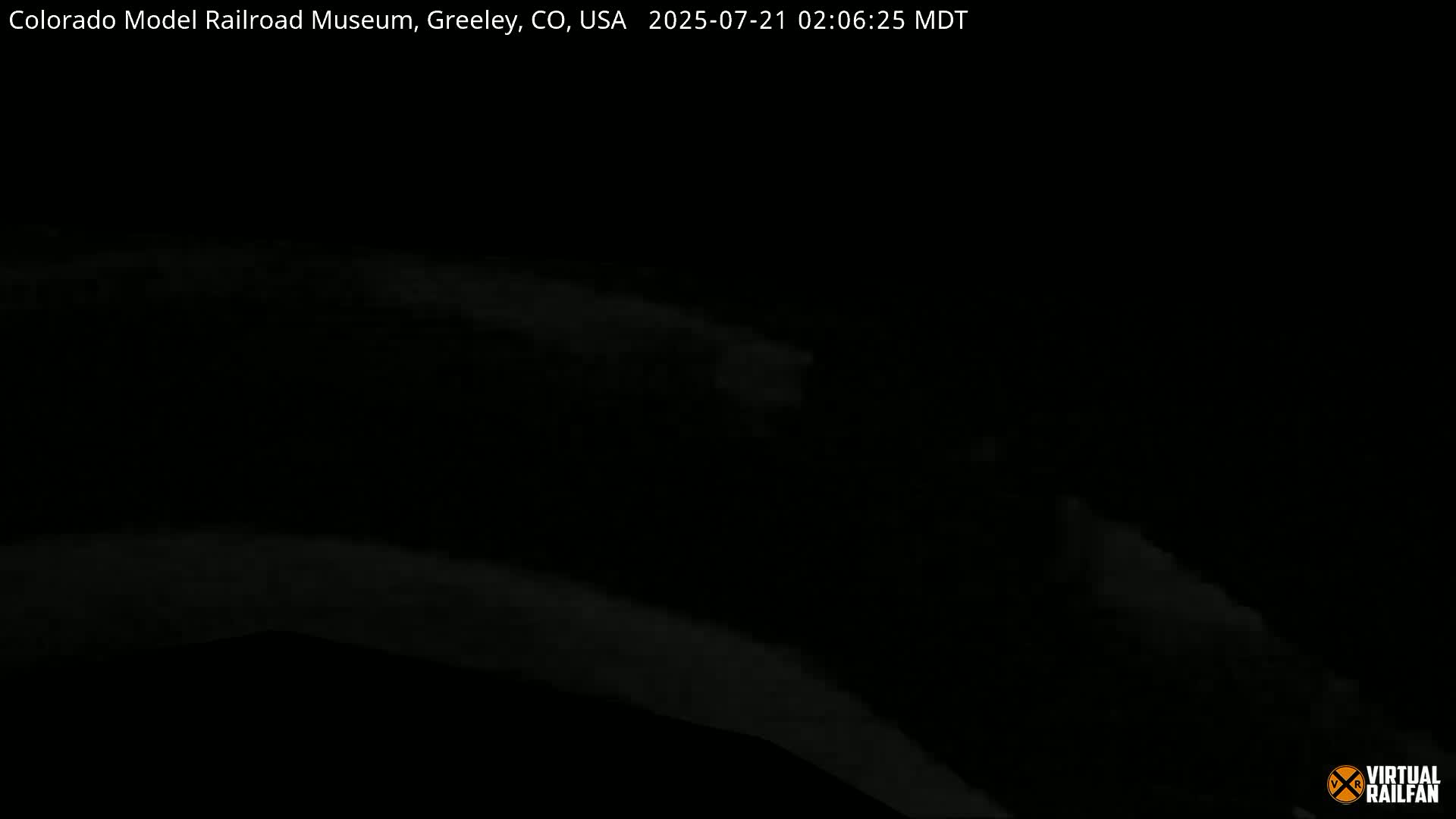 A very dark, nighttime image shows faint, blurry light in the lower portion.