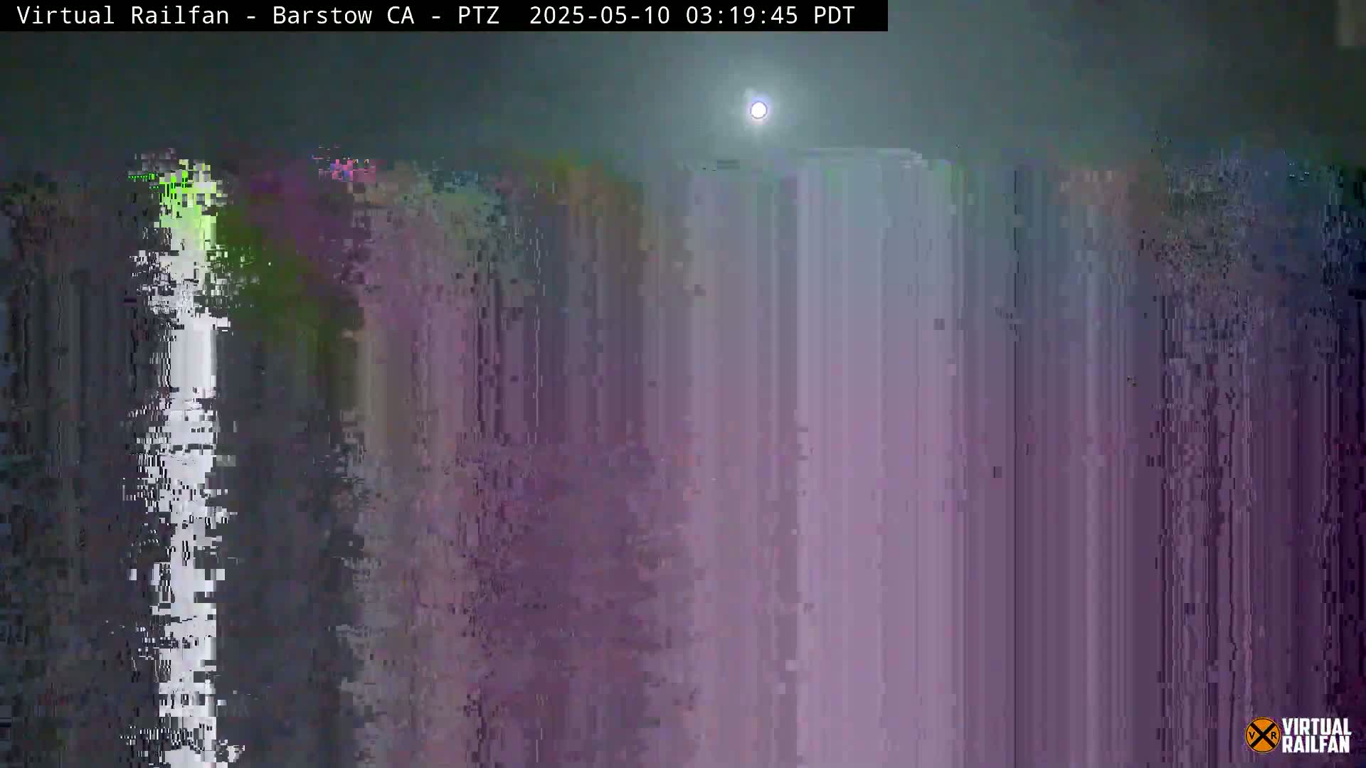 A nighttime, hazy outdoor scene shows a bright moon and a mostly obscured, blurry view of what seems to be a tall structure or building.
