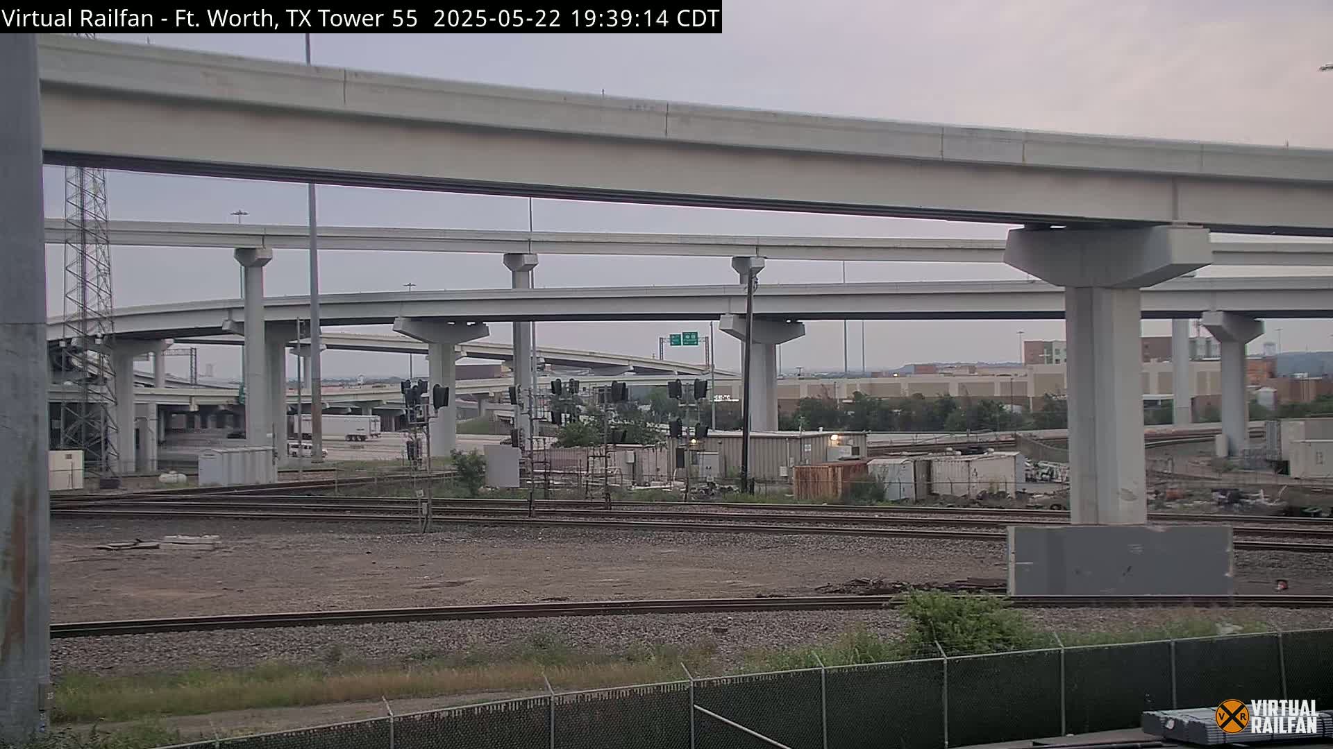 Railroad tracks and a complex overpass system are seen under an overcast sky.