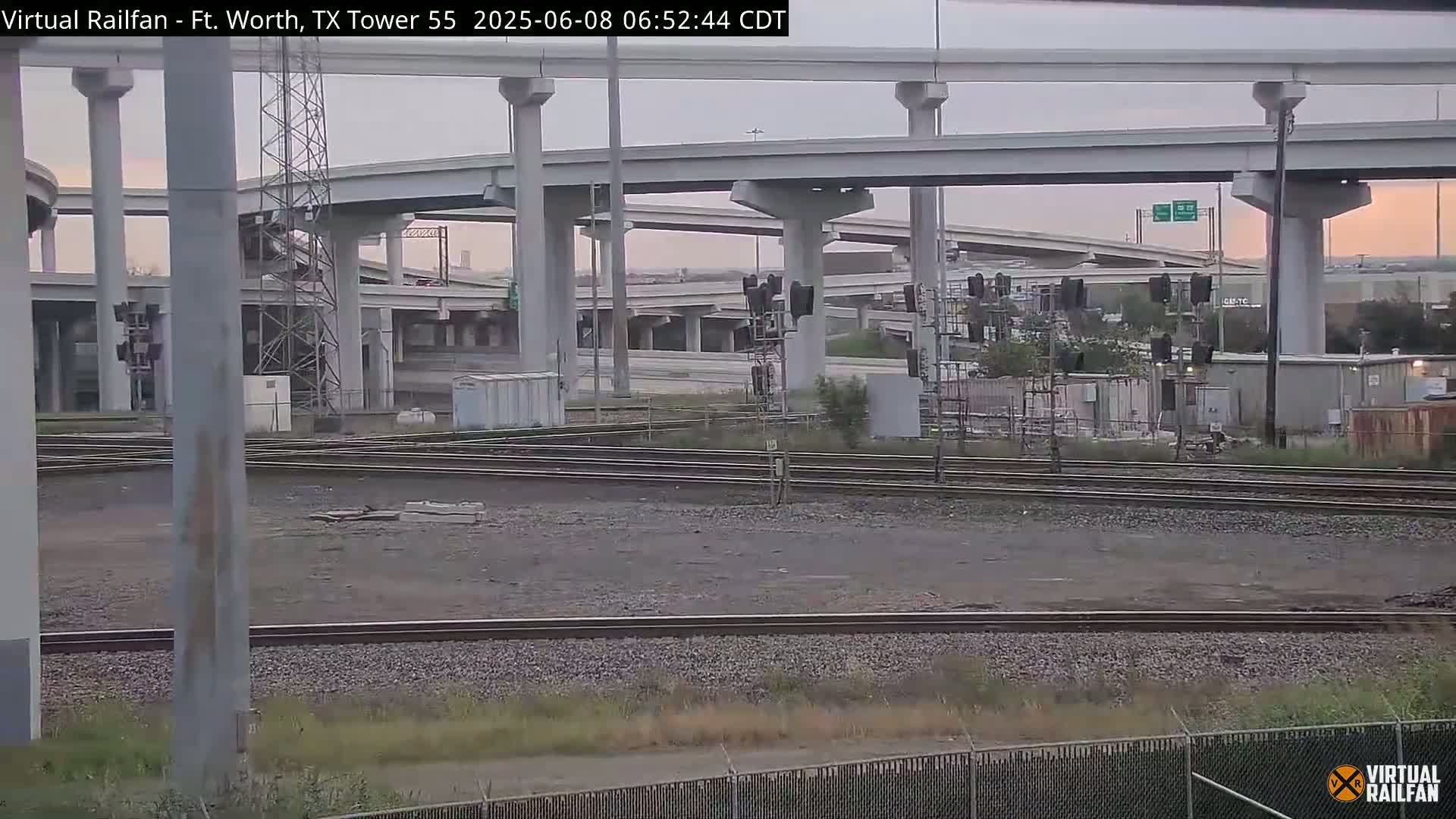 A view of railroad tracks and an overpass on an overcast day.