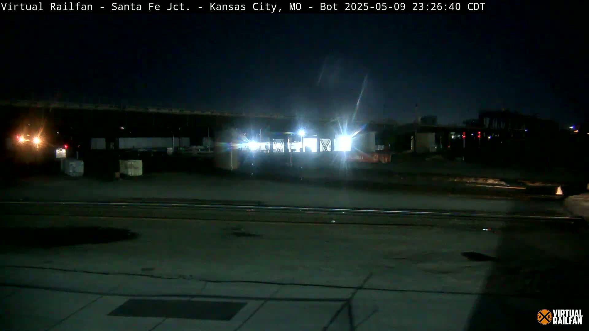 A nighttime view of a train in a rail yard.