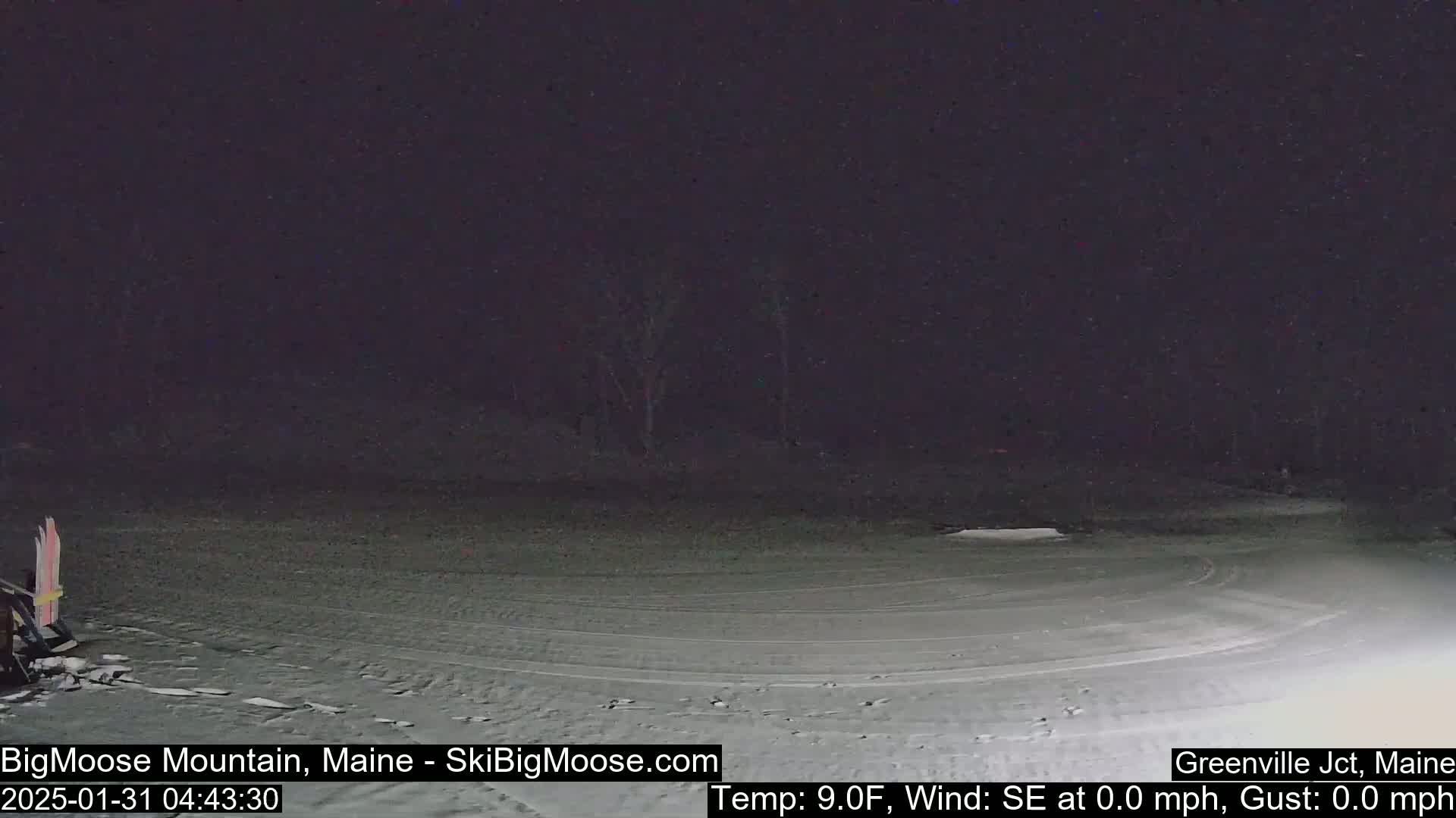 A snow-covered area at night with a calm wind, under a dark sky.