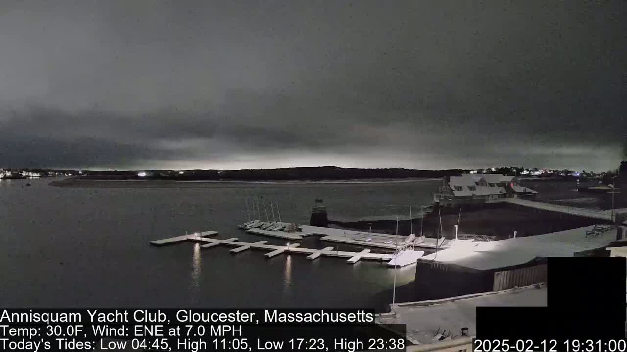 A snow-covered marina at night under a dark, overcast sky.