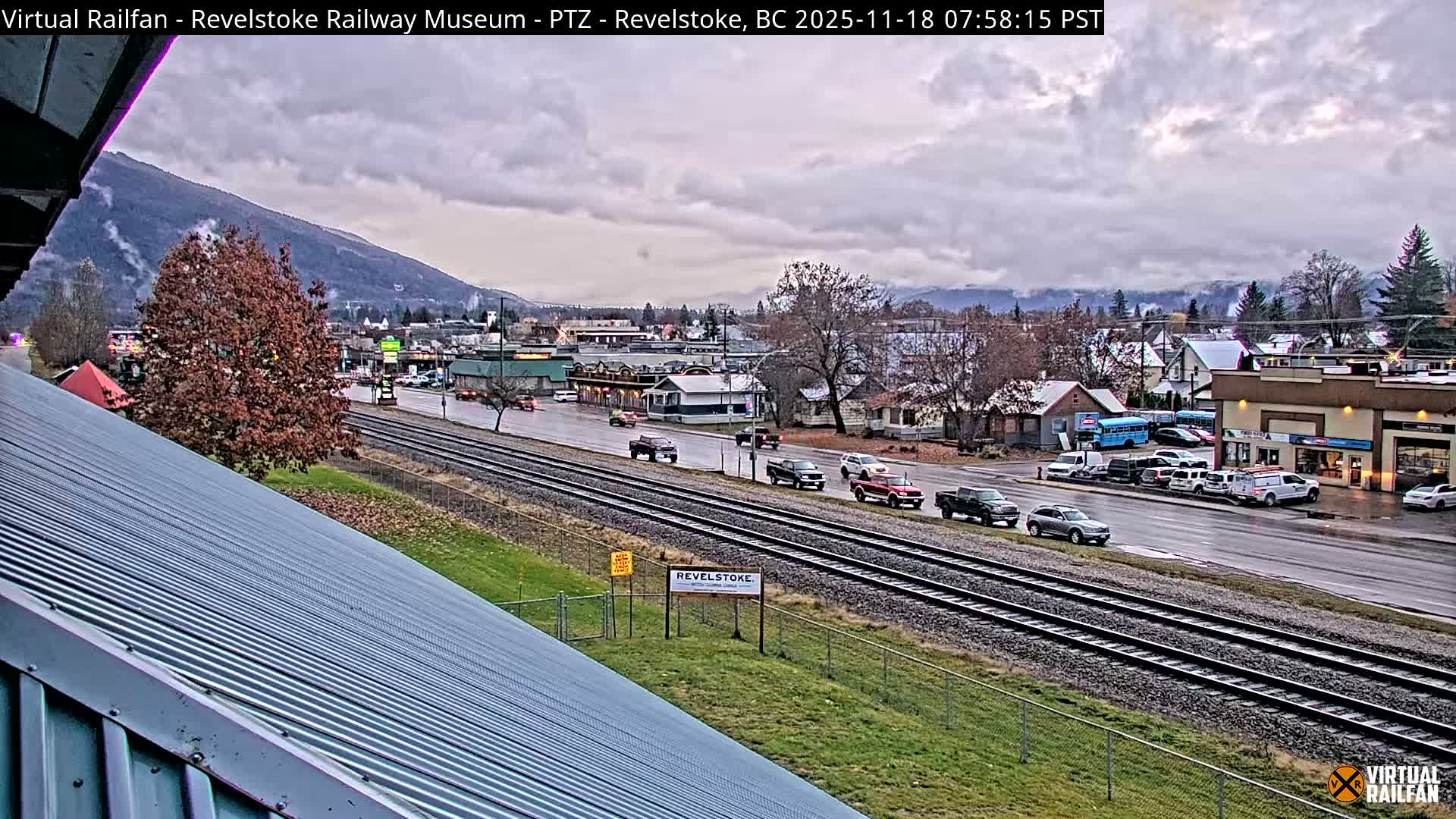 A nighttime view of a town with a railway line running through it, under a clear sky.