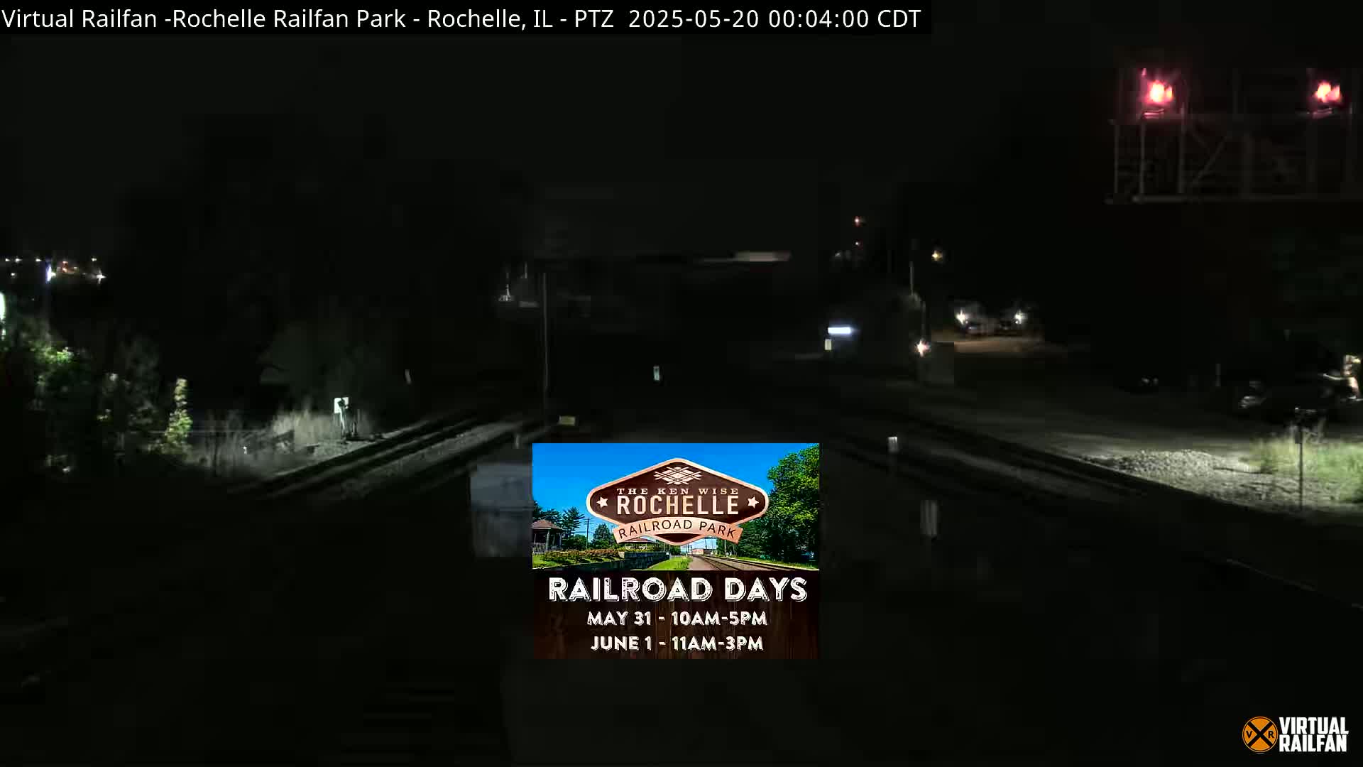 A nighttime, low-light view of a railroad crossing with minimal traffic.