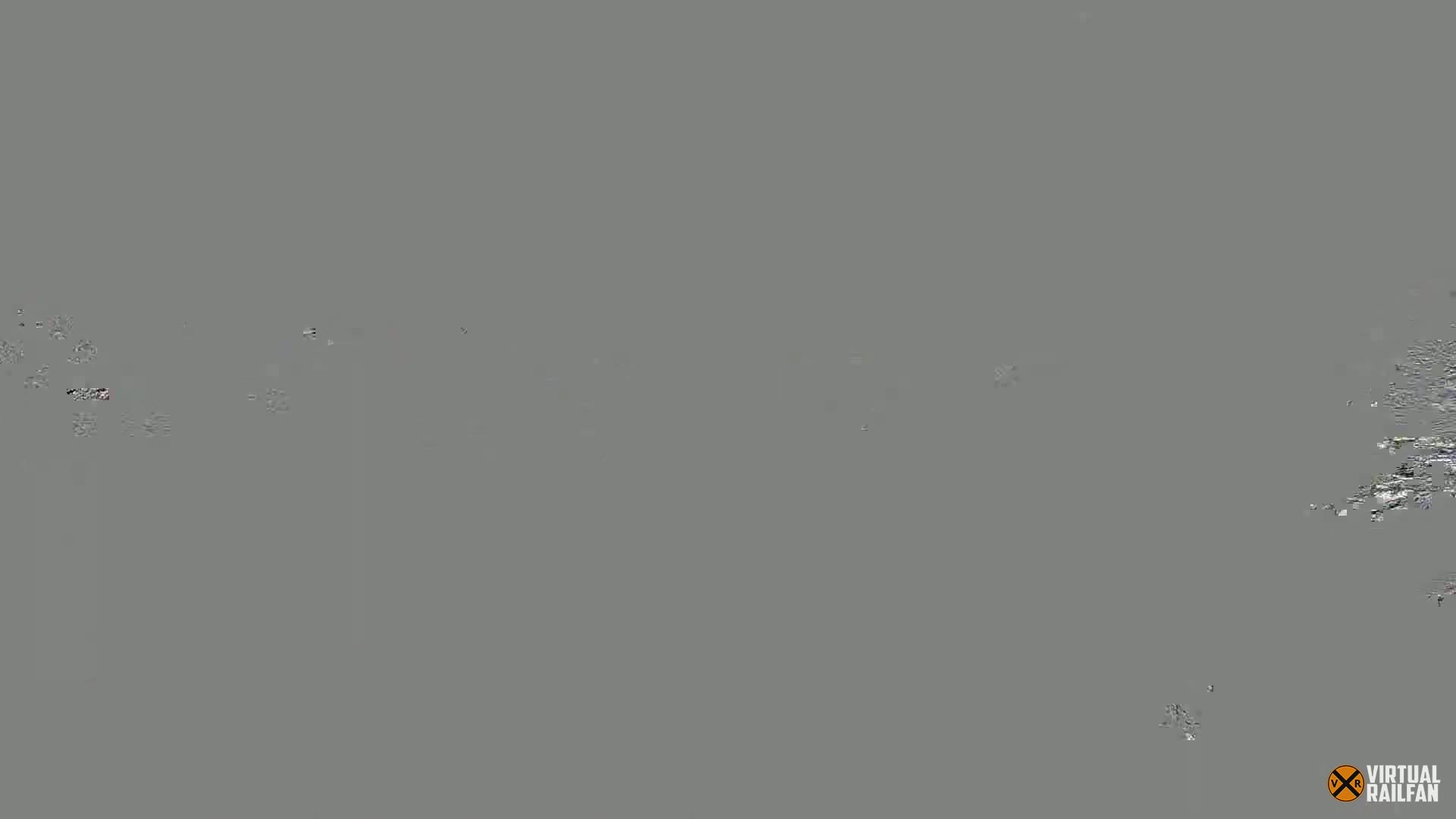 A mostly gray image with small, scattered, distorted elements.