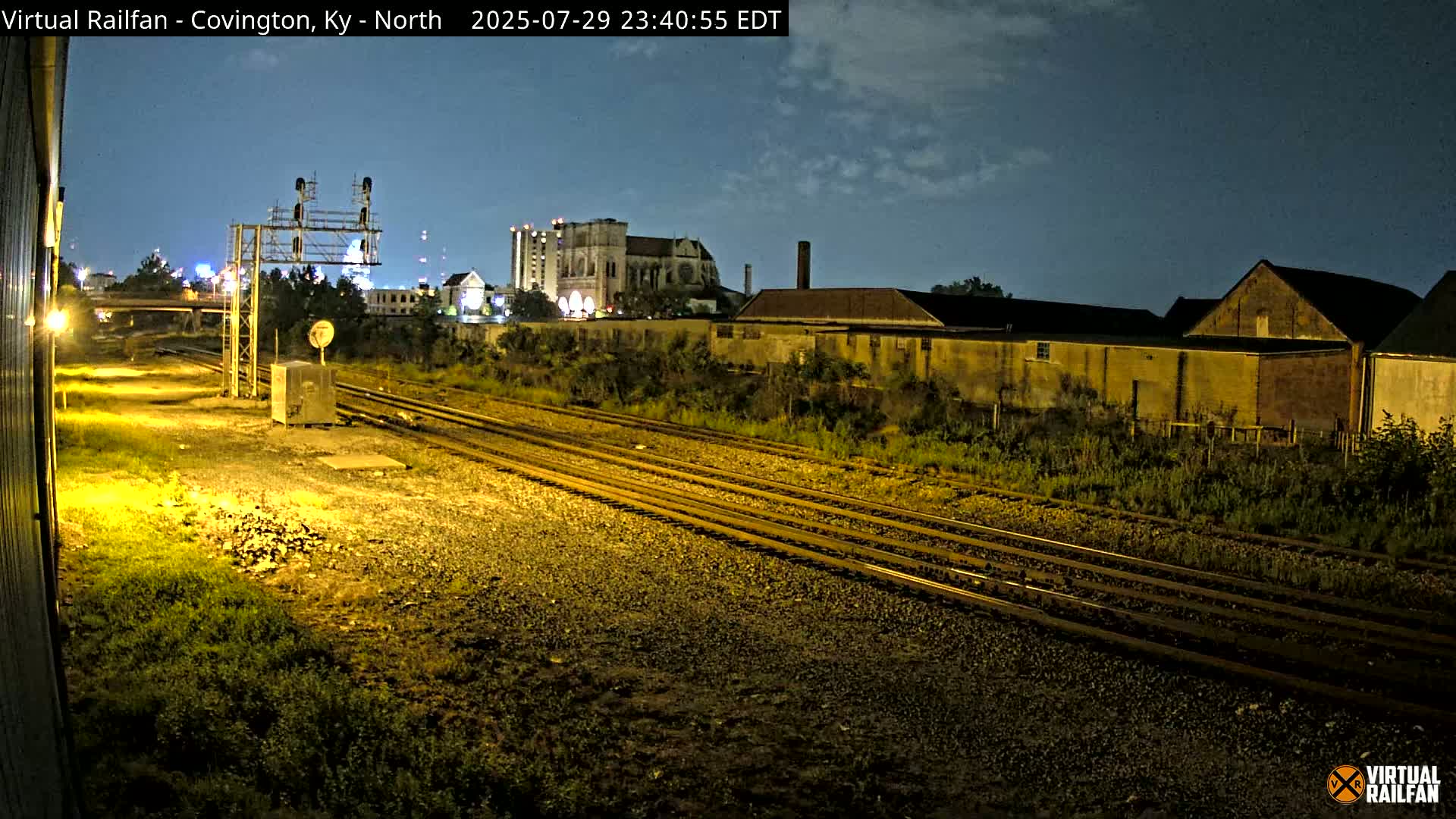 A CSX freight train moves along the tracks at night under a dark, clear sky.