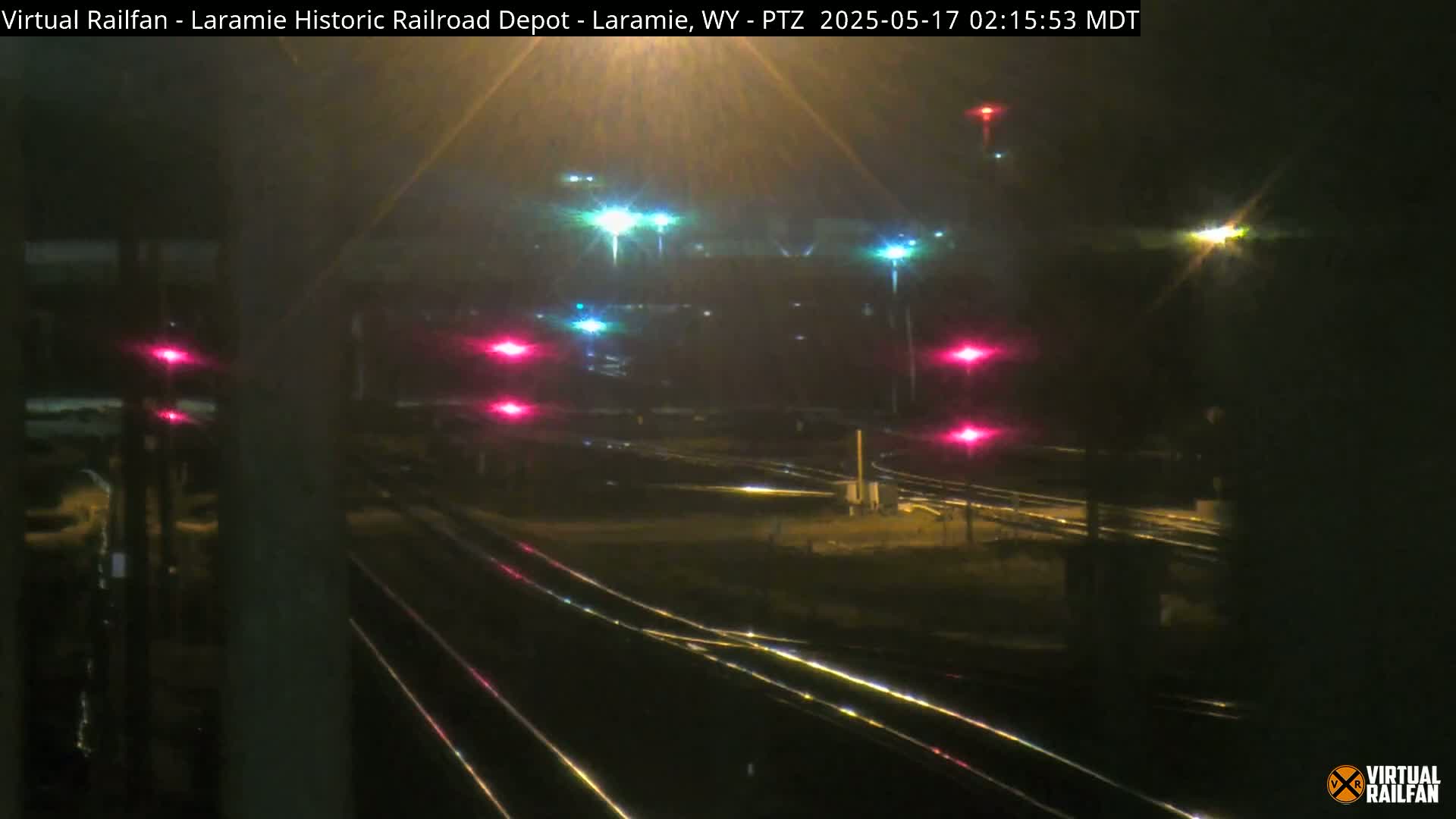 A nighttime view of railroad tracks and signal lights.