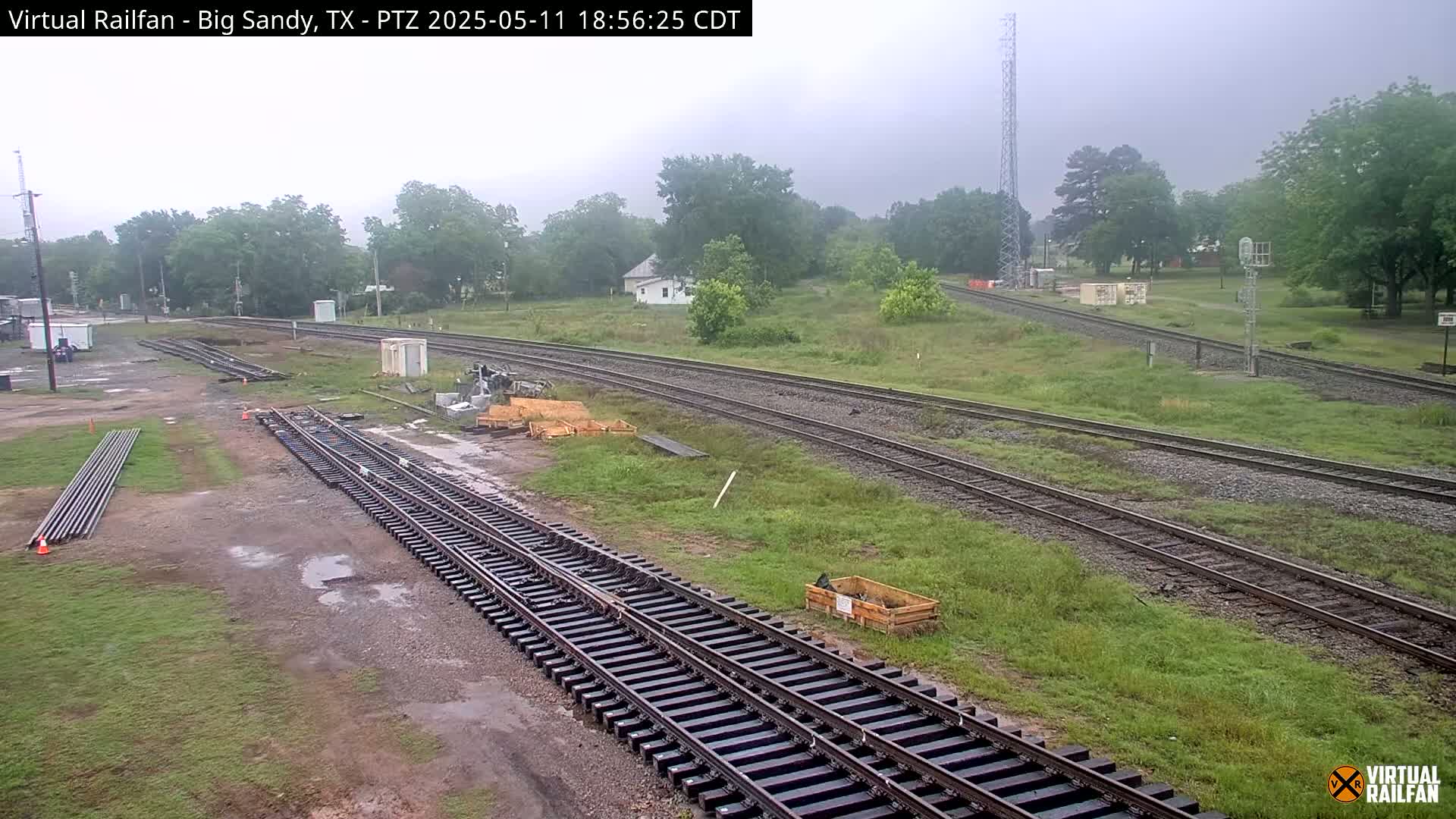 A railway yard with several sets of tracks undergoing maintenance or construction under an overcast sky.