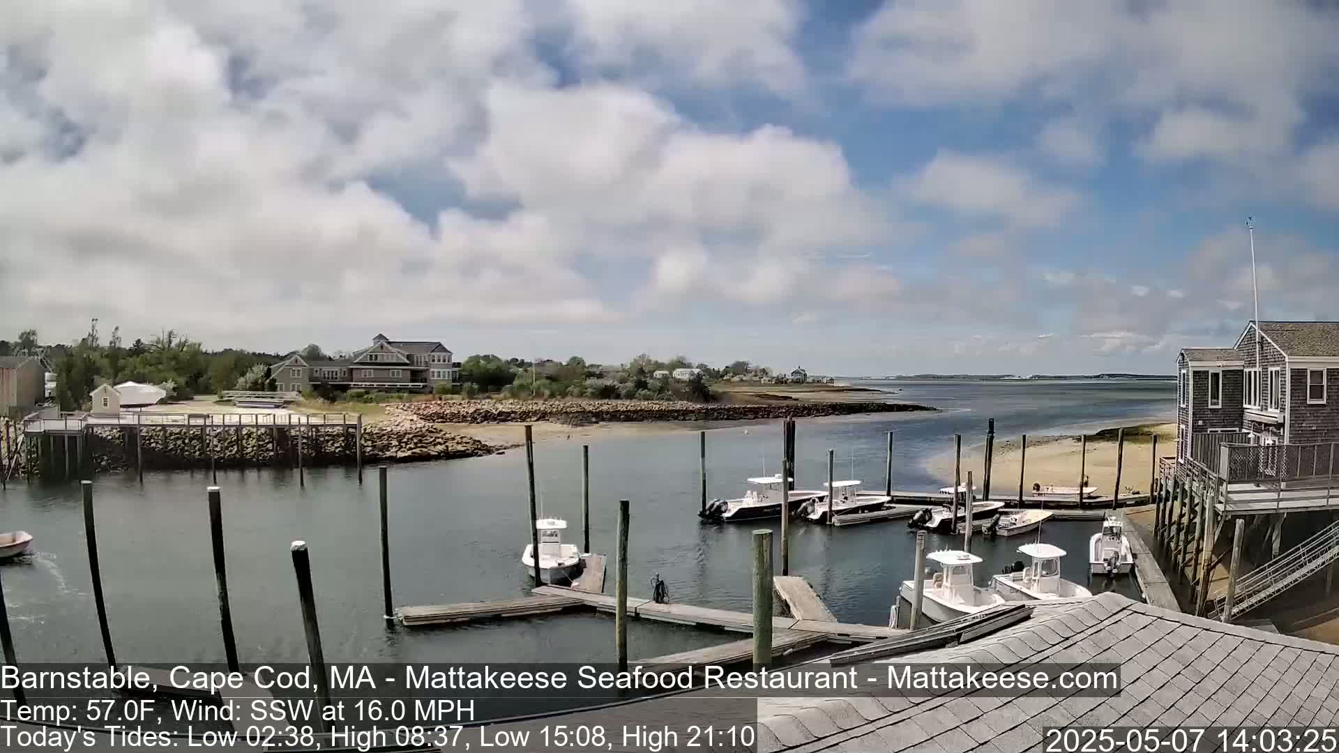 Several boats are docked at a marina on a partly cloudy day with a moderate south-southwesterly wind.