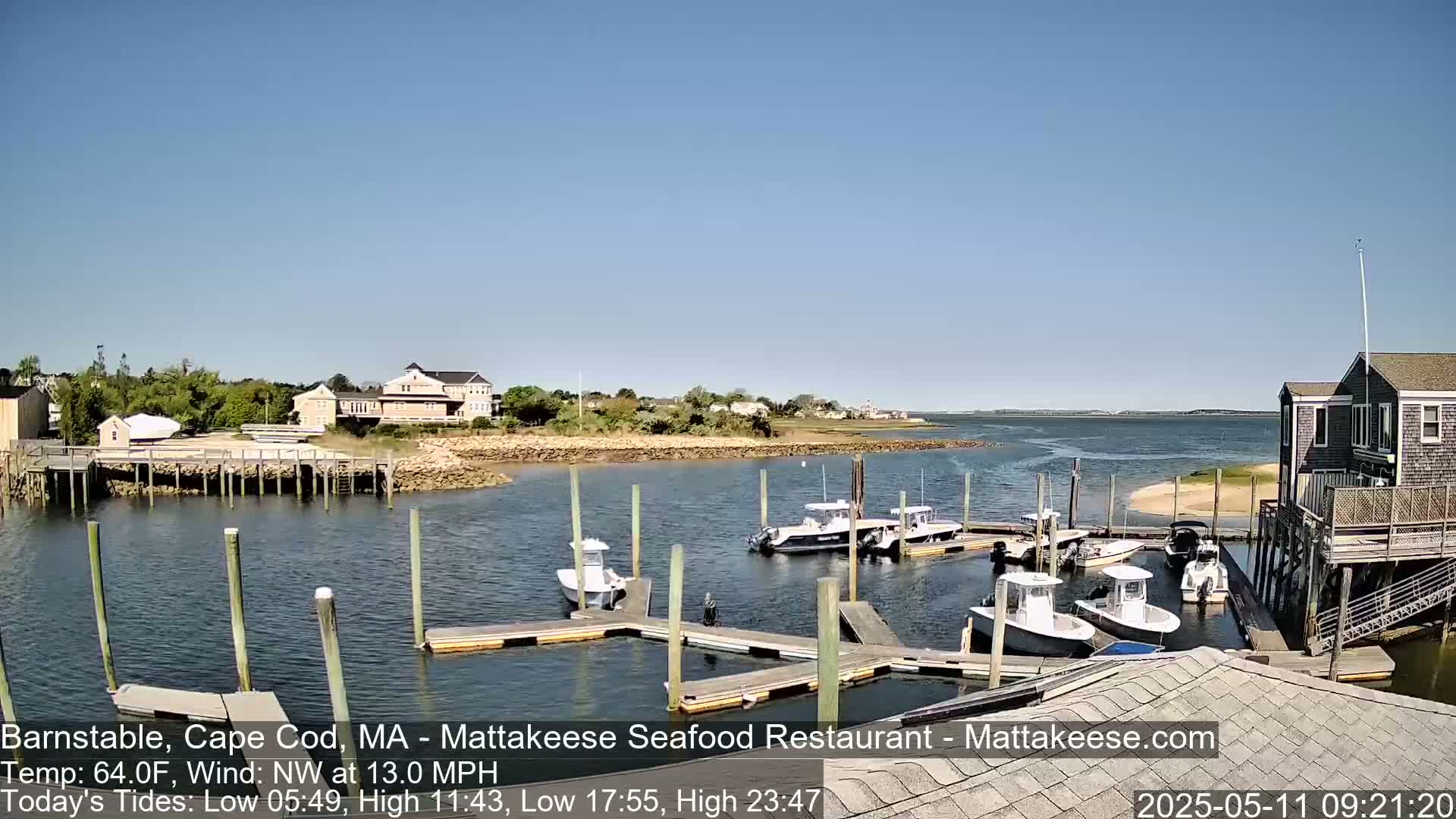 Several boats are docked at a marina on a sunny day with a northwest wind of 13 mph.