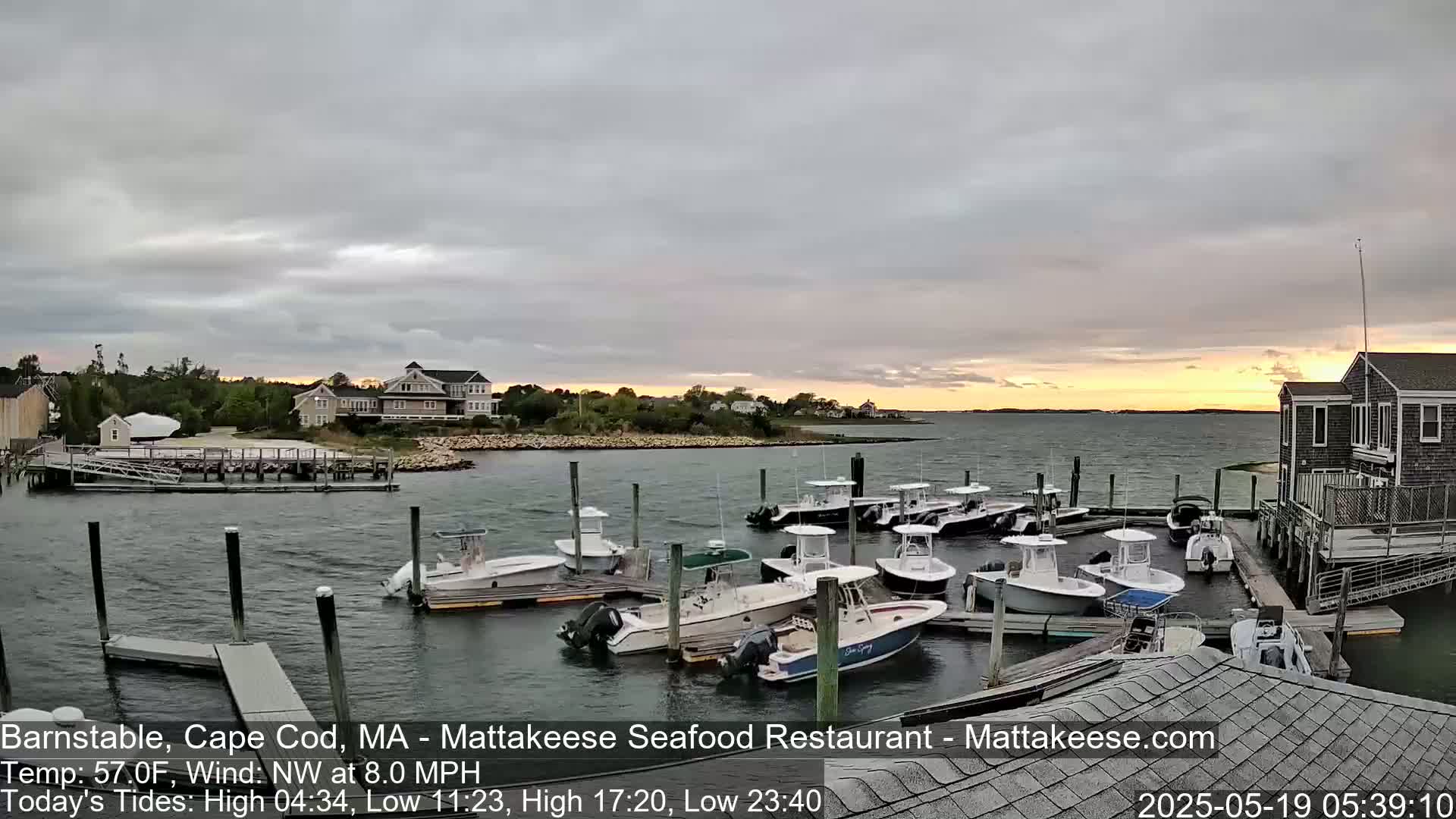 Many motorboats are docked at a marina during a partly cloudy sunset with a northwest wind.