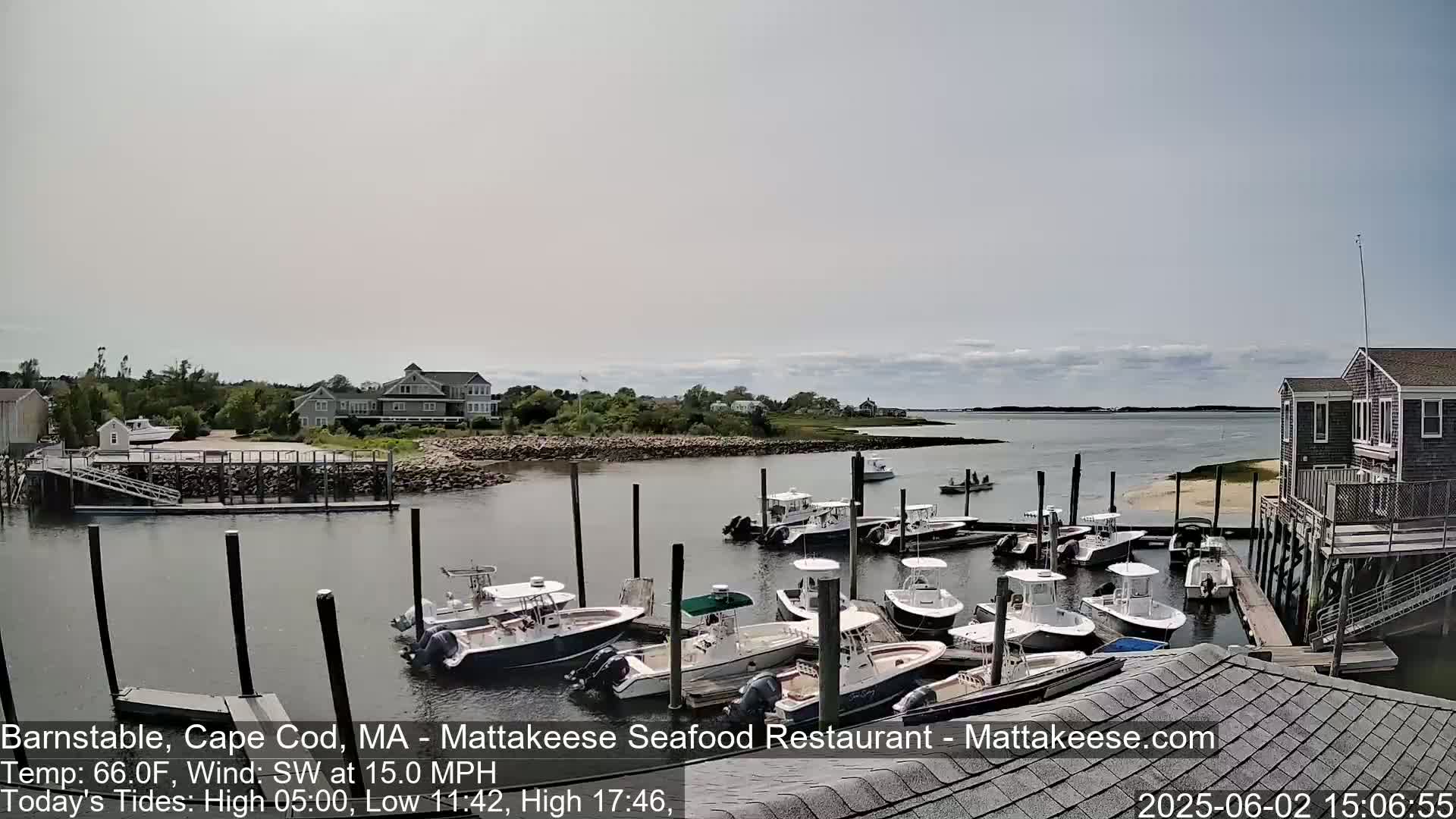 Numerous boats are docked at a marina on a partly cloudy day with a southwest wind.
