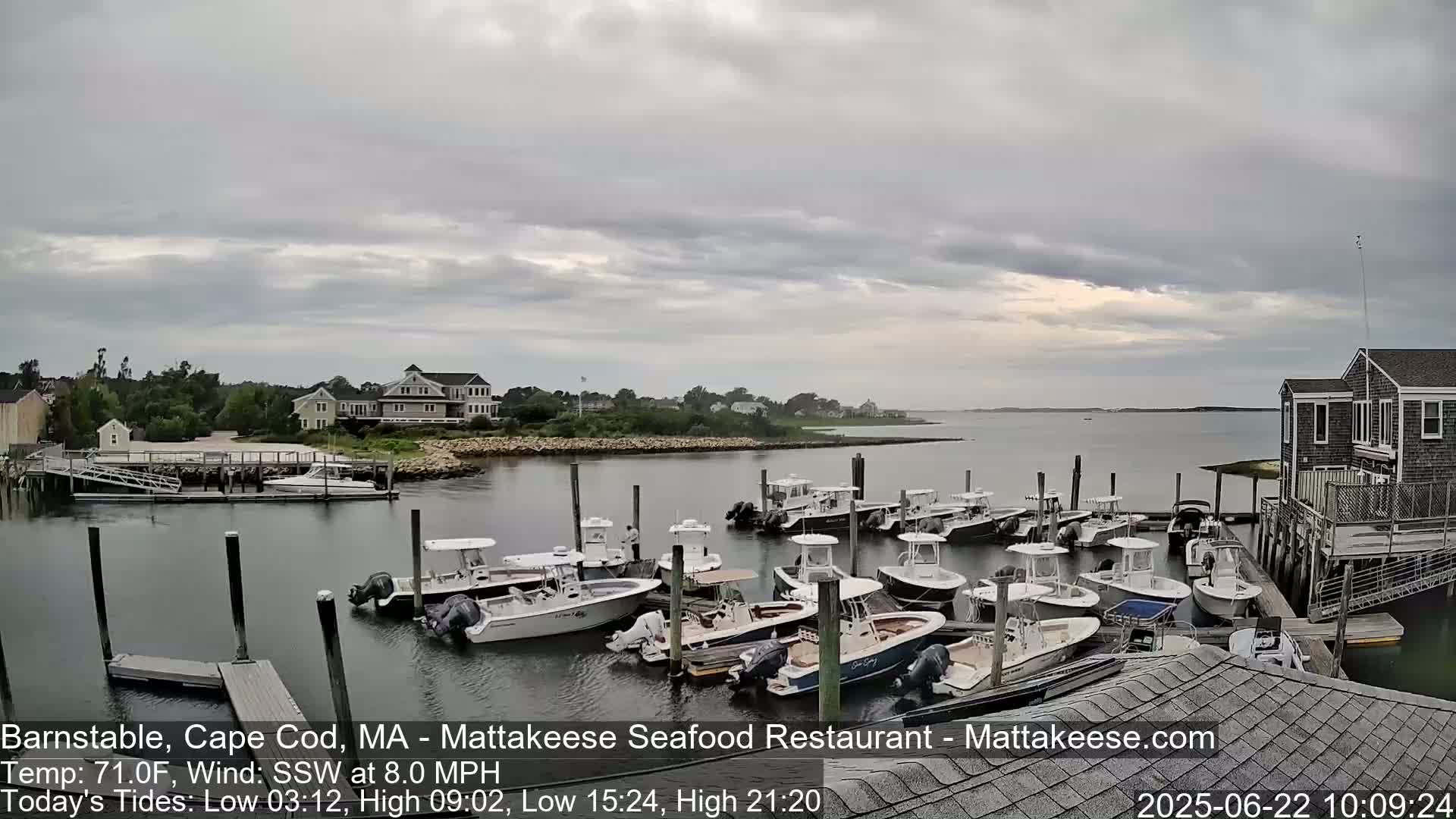 A harbor filled with numerous boats under a mostly cloudy sky.
