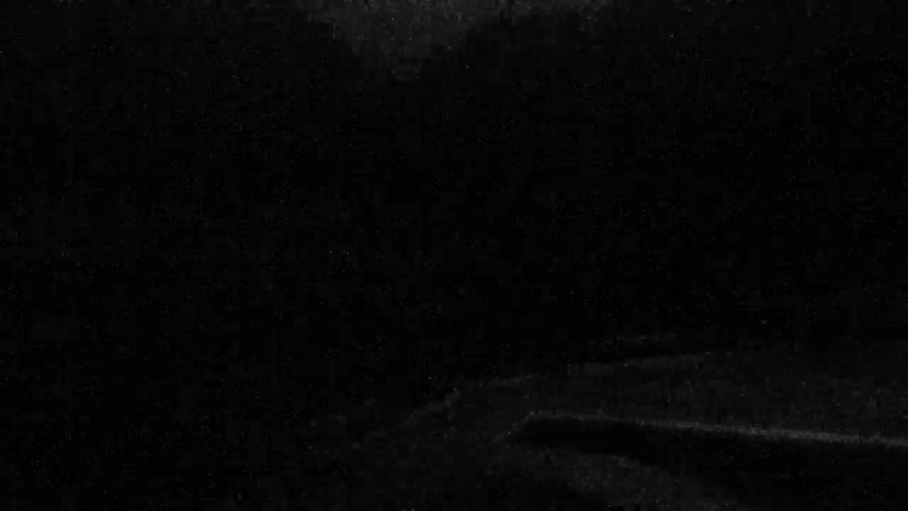 The image shows a dark, possibly black, textured surface with subtle folds and variations in shading.
