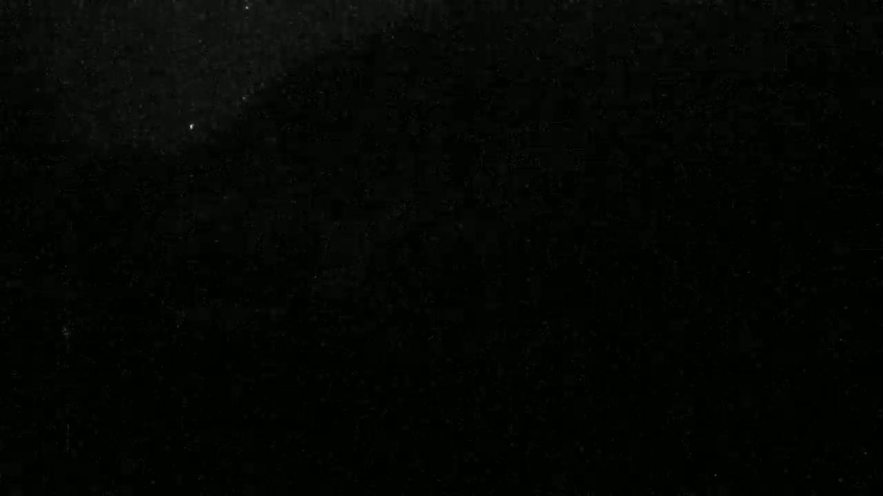 The image shows a mostly black background with scattered tiny specks of lighter gray.