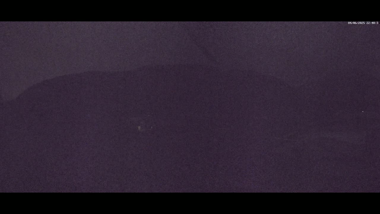 A dark, blurry image shows a mostly featureless, dark-purple landscape at night.