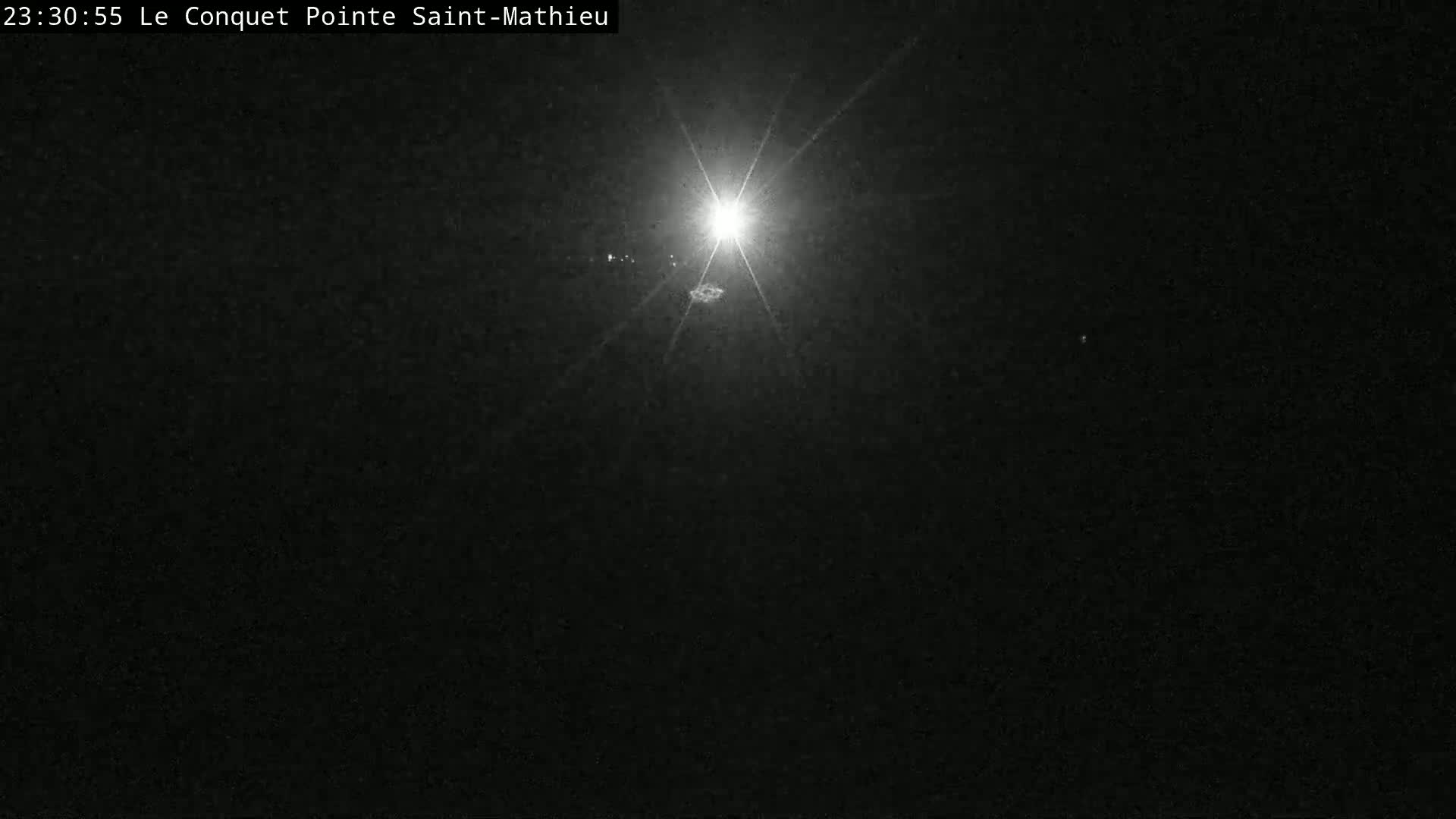 A bright light shines in the center of a dark, nighttime scene.