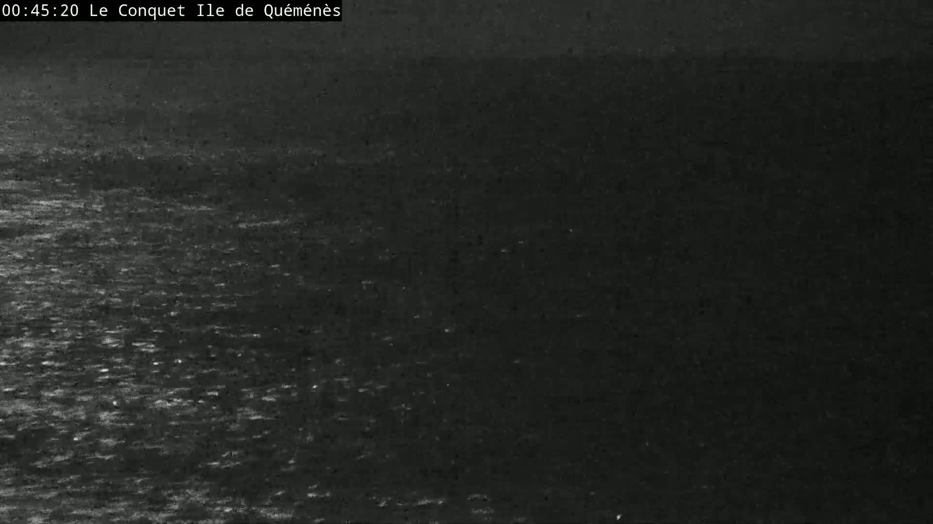 A dark, nighttime image shows a body of water with slightly choppy waves.