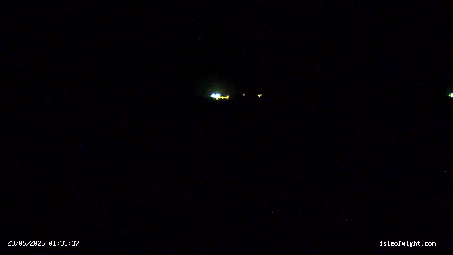 A dark, nighttime scene shows a few faint, distant lights.