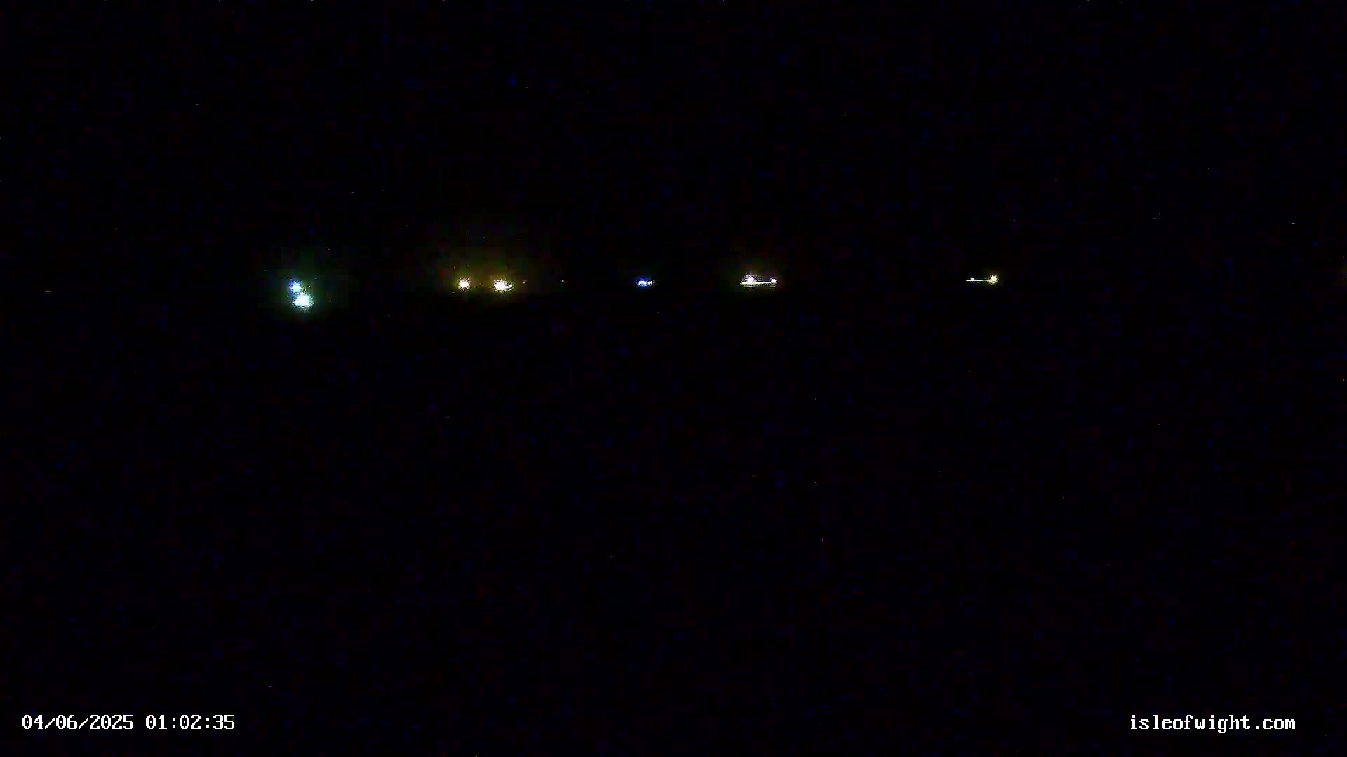 Several small, distant lights are visible in the nighttime darkness.