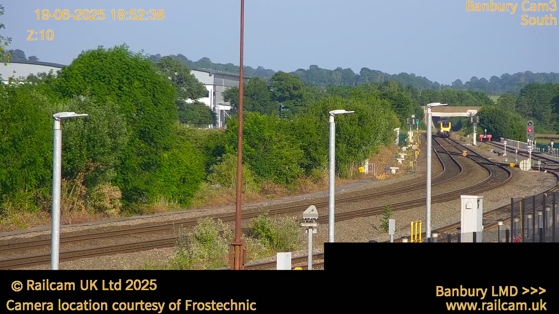 A train passes through a railway station on a sunny day.