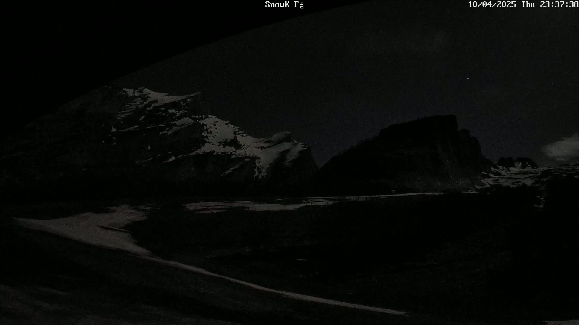 Snow-capped mountains are visible under a dark, nighttime sky.