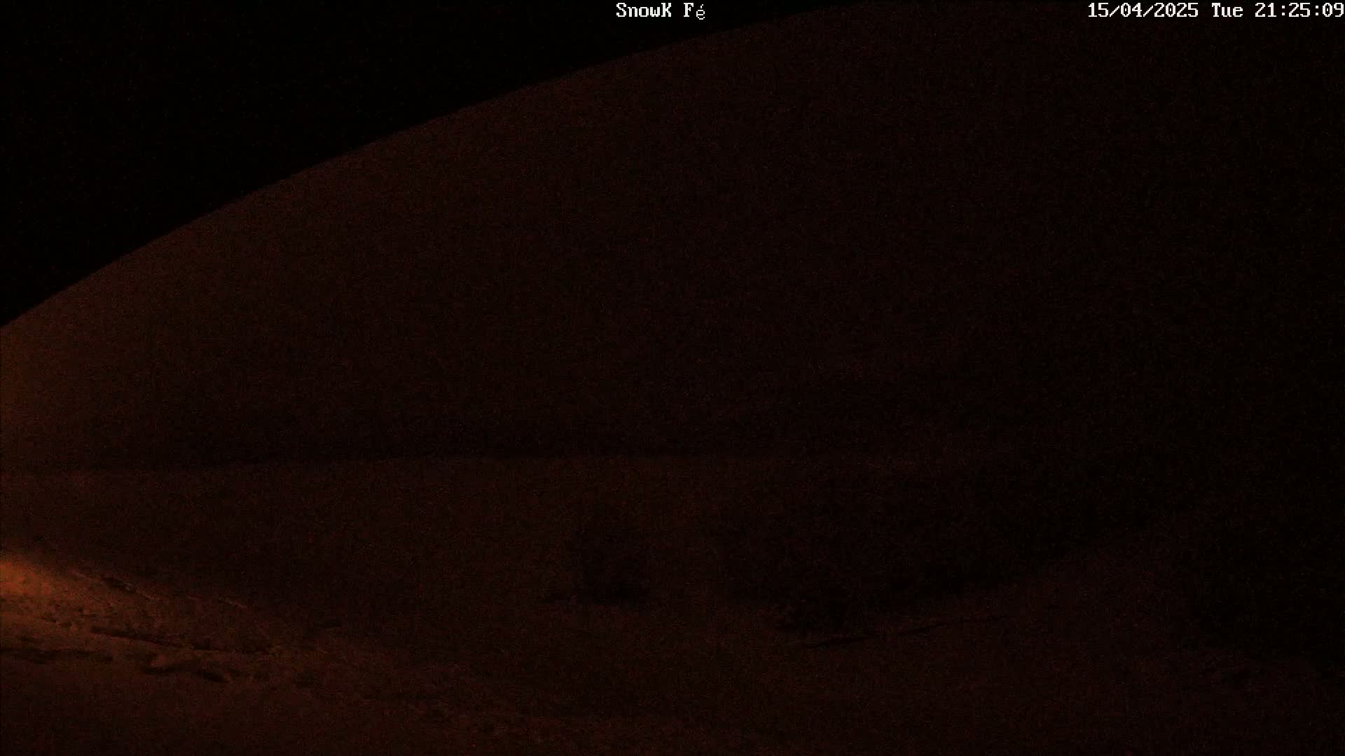 A dark, snow-covered landscape is visible at night.