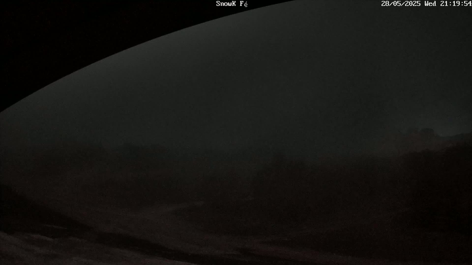 A dark, foggy landscape is visible from what appears to be a slightly elevated vantage point at night.