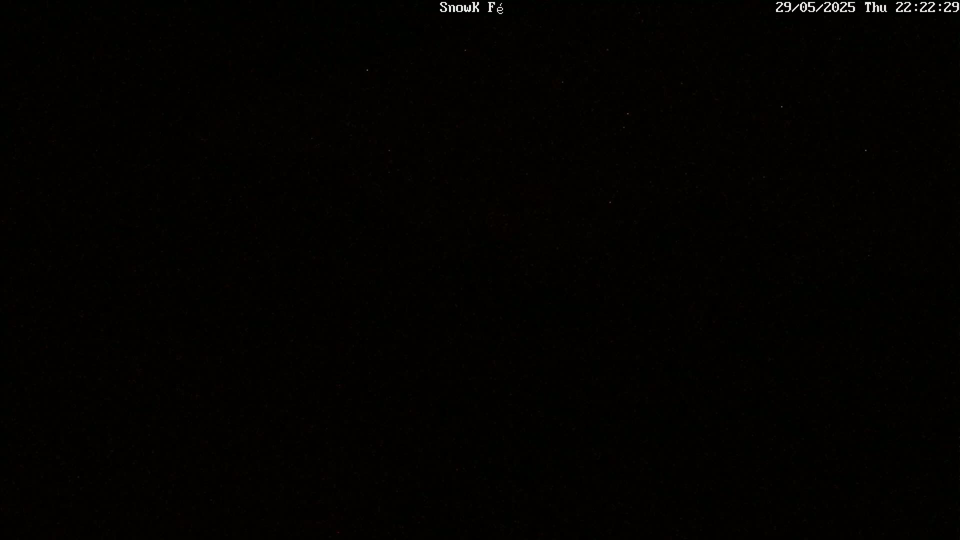 A completely black image with a few faint, scattered specks of light.