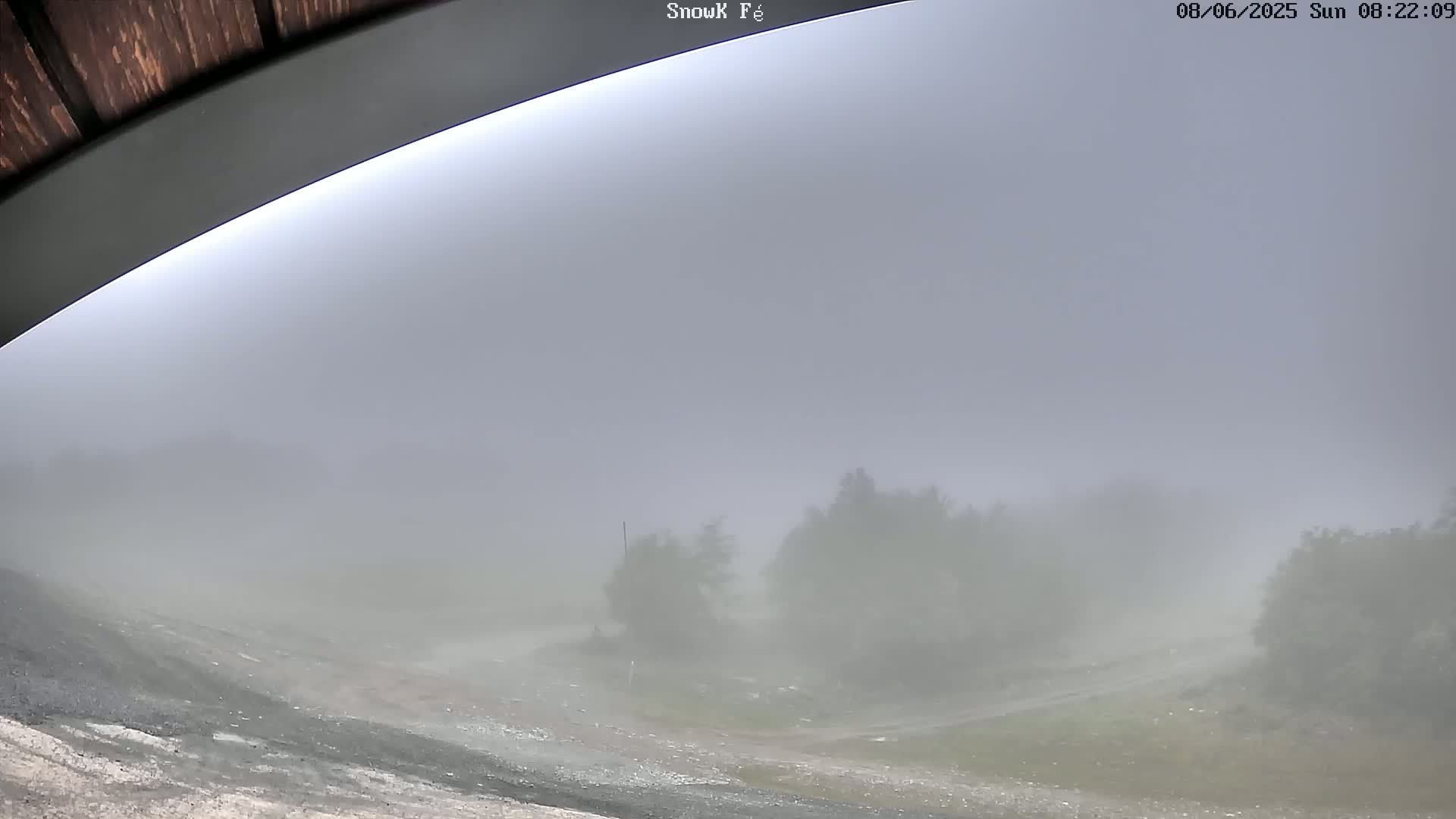 A foggy landscape is visible from under an overhang, showing indistinct vegetation and a dirt path.
