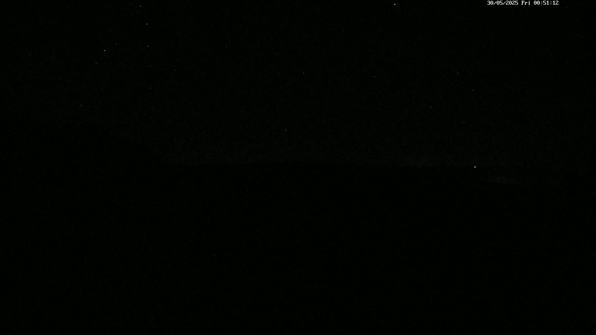 A dark, nighttime scene shows a star-filled sky above a dark, indistinct horizon.