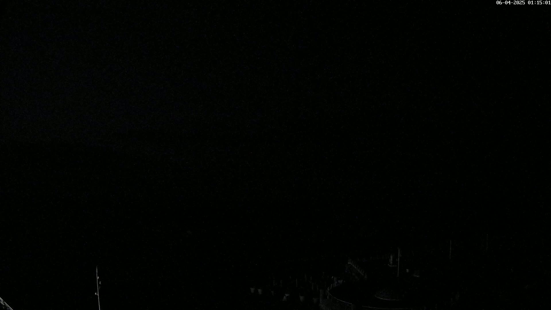 A dark, nighttime scene shows a dimly lit area below a completely black sky.
