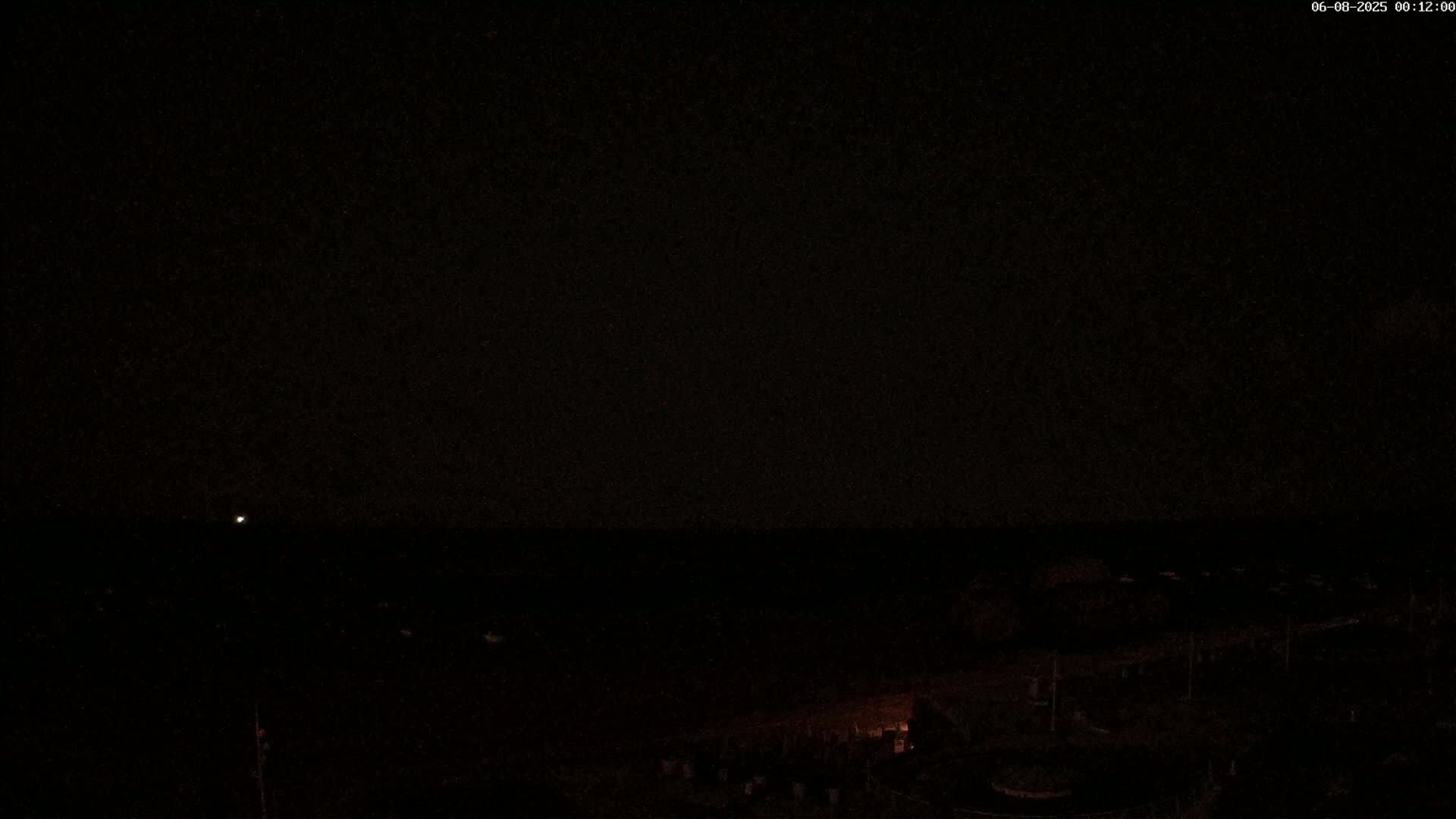 A dark, nighttime scene shows a dimly lit landscape under a clear, starless sky.