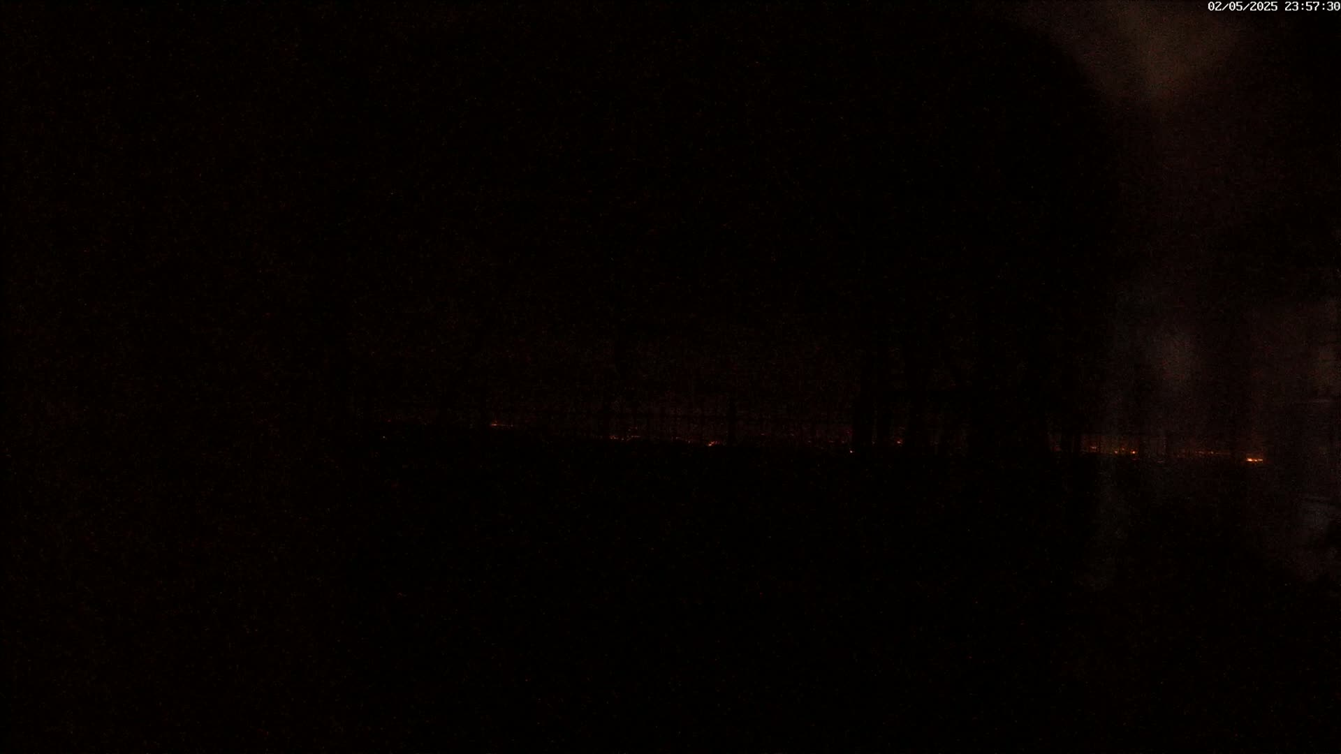 A dark, nighttime scene shows a faint orange glow on the horizon.