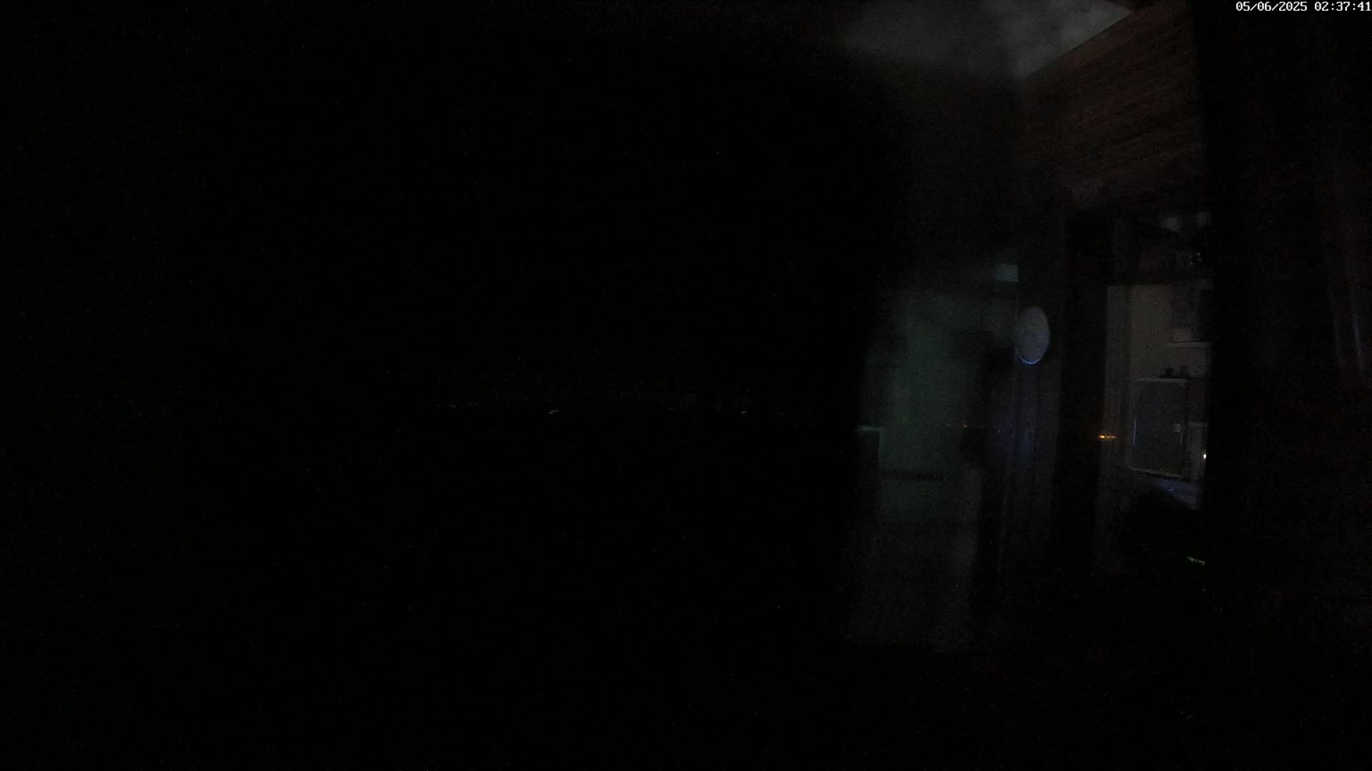 A dimly lit interior space is visible through a dark window at night.